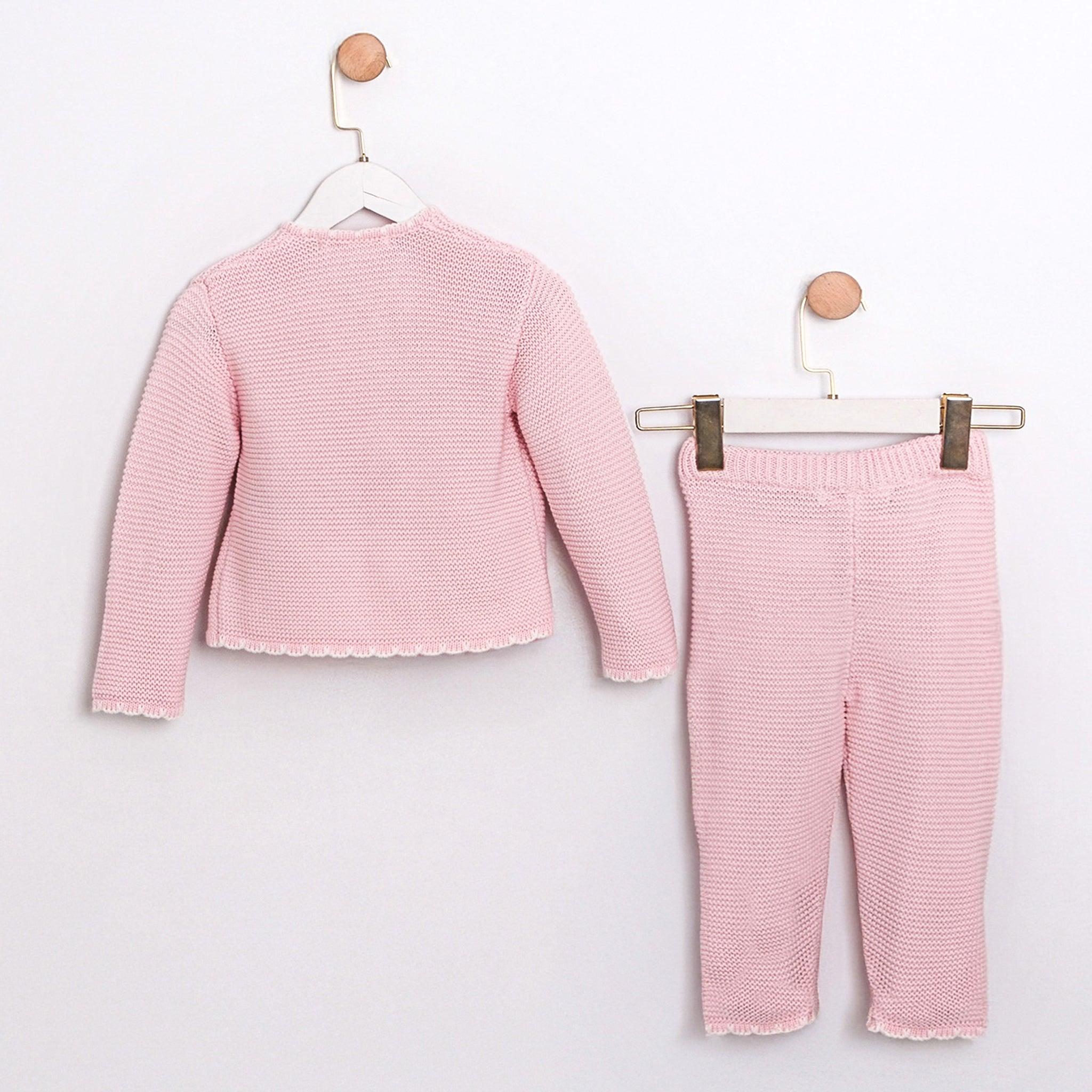 Two-piece pastel pink baby outfit featuring wrap top and knit leggings