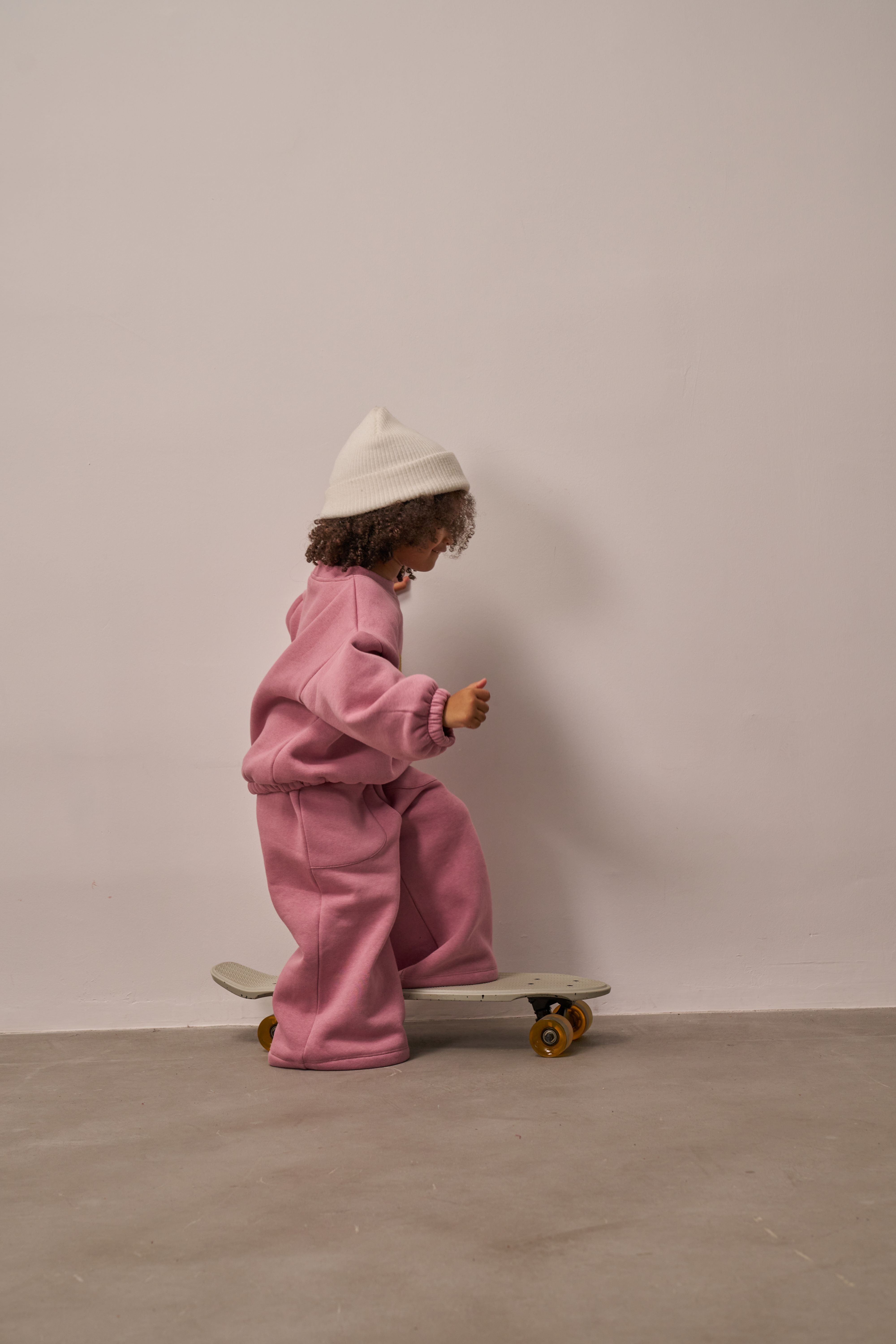 Pink two-piece kids sweat outfit with wide-leg pants and relaxed top.