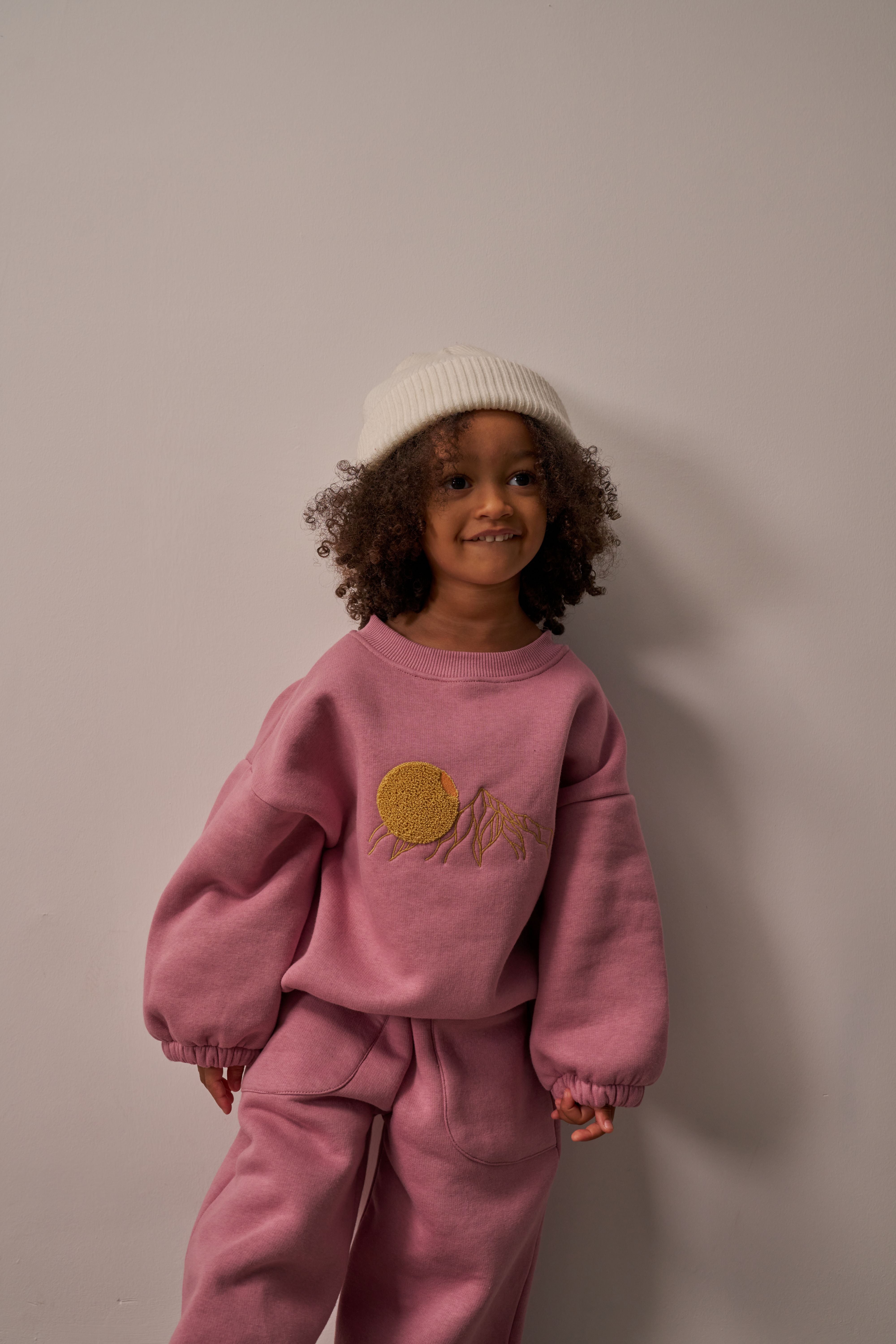 Pink oversized kids sweat set with embroidered sun and mountain design