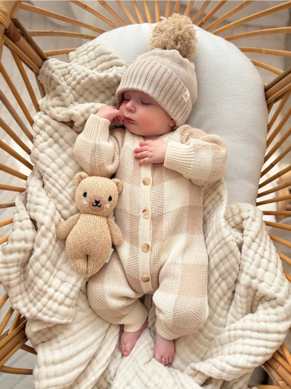 Soft organic baby one-piece romper in a beige checkered knit.