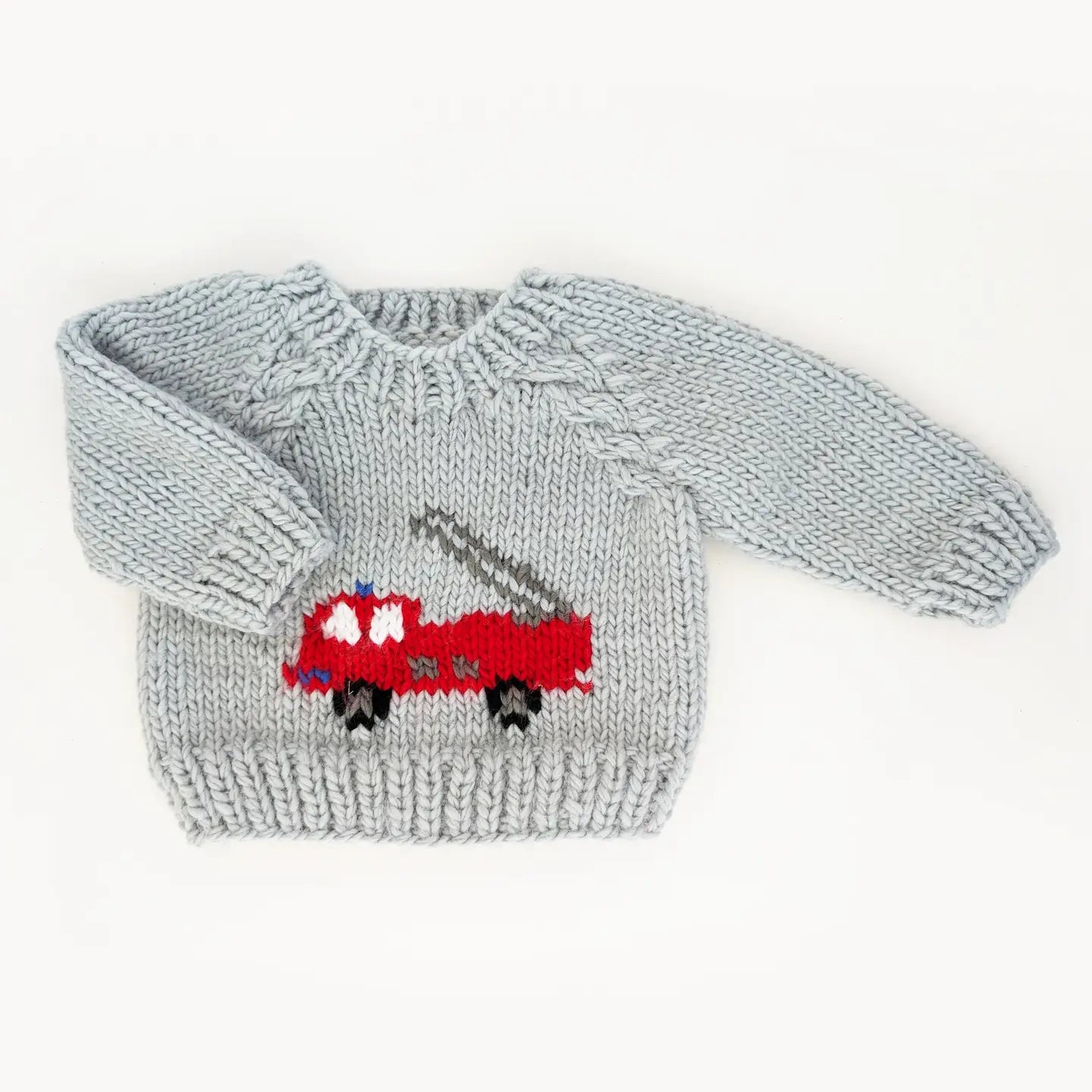 Knitted sweater with a red truck design on a white background