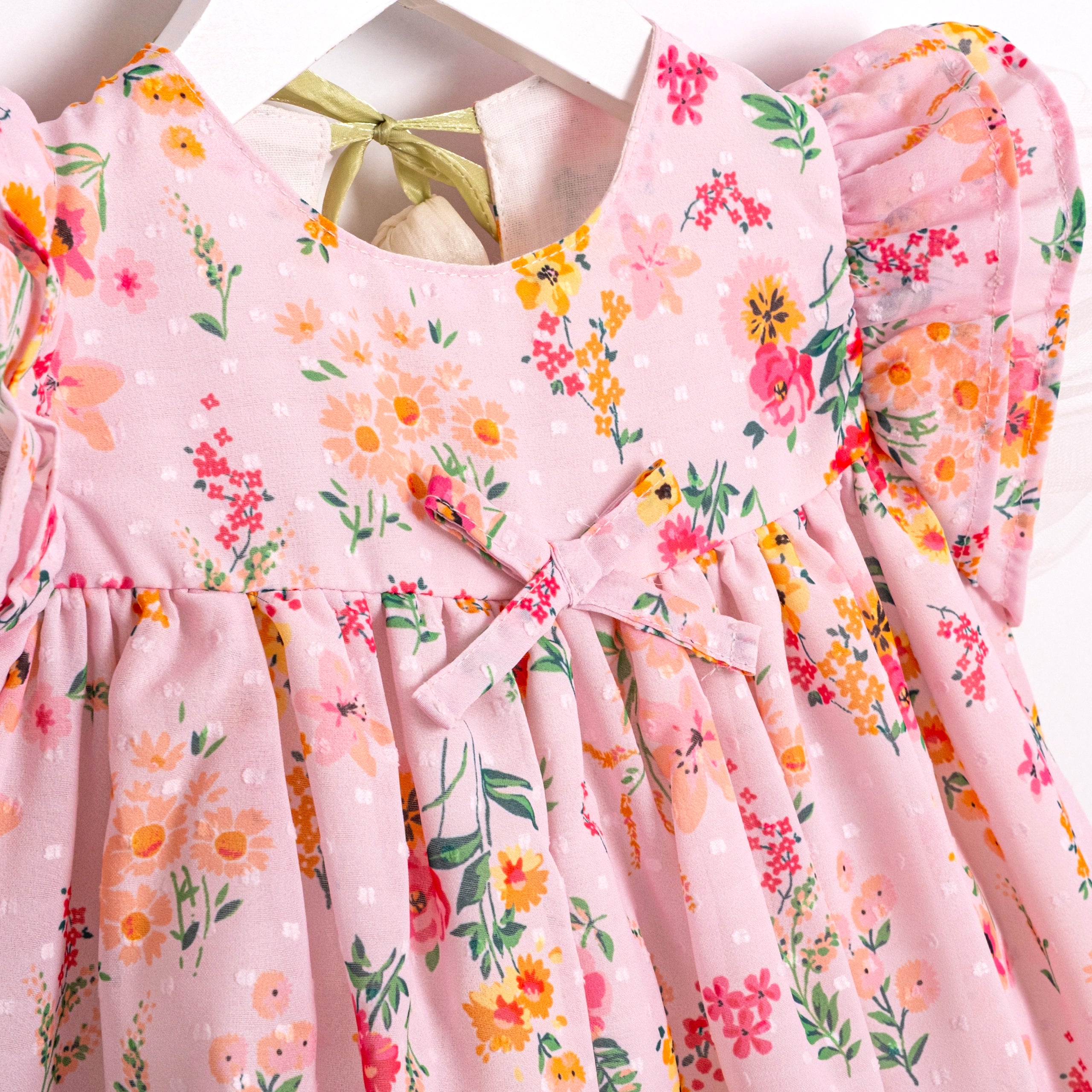 Pink garden print baby dress with bow detail