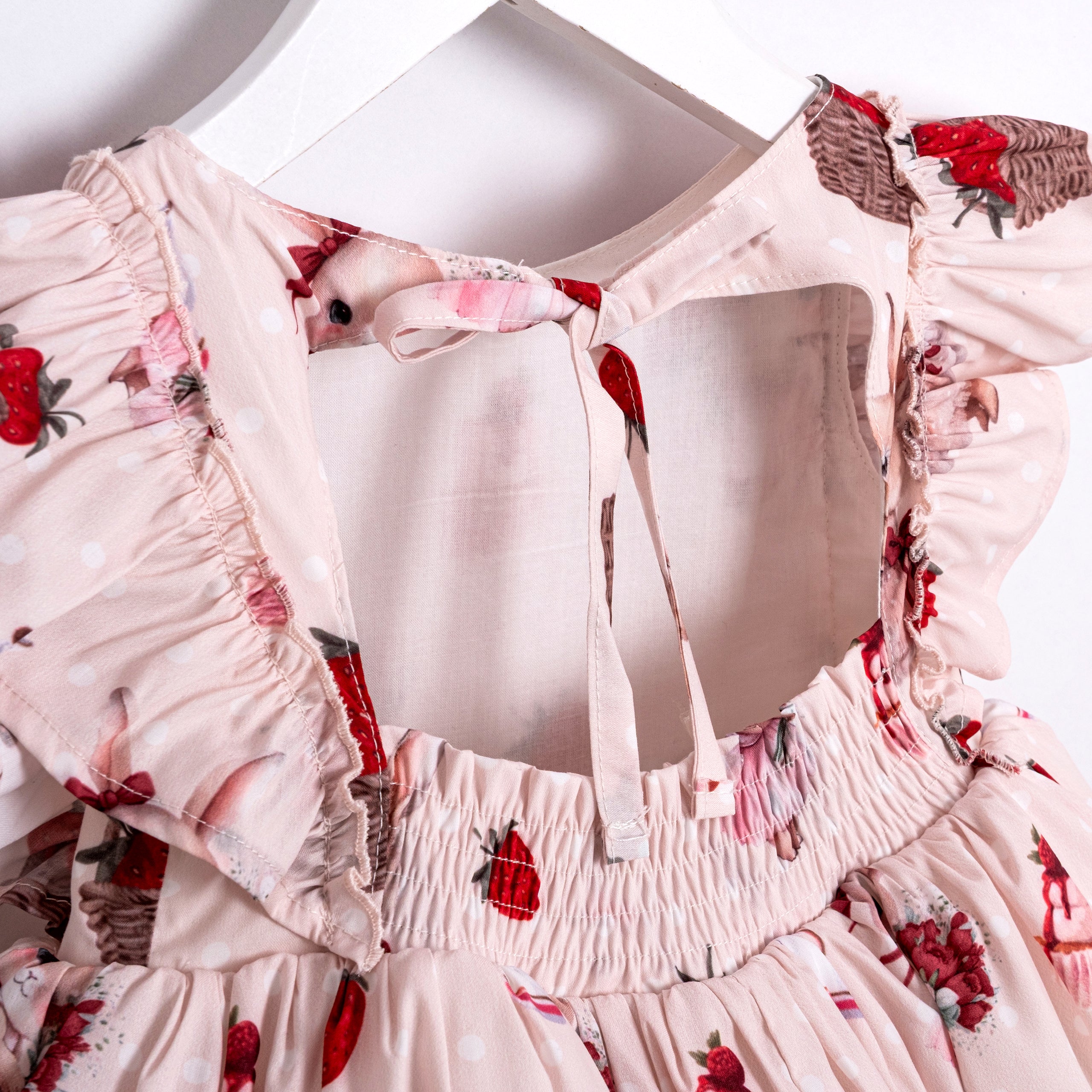Cute pink baby dress with bunny illustrations and strawberries