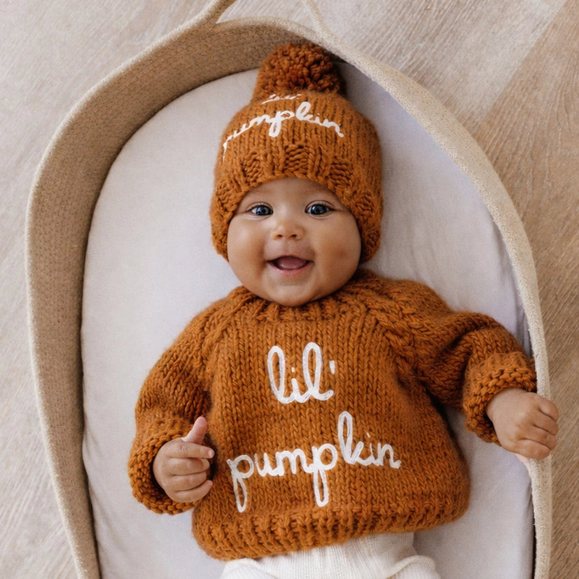 baby wearing orange knit sweater