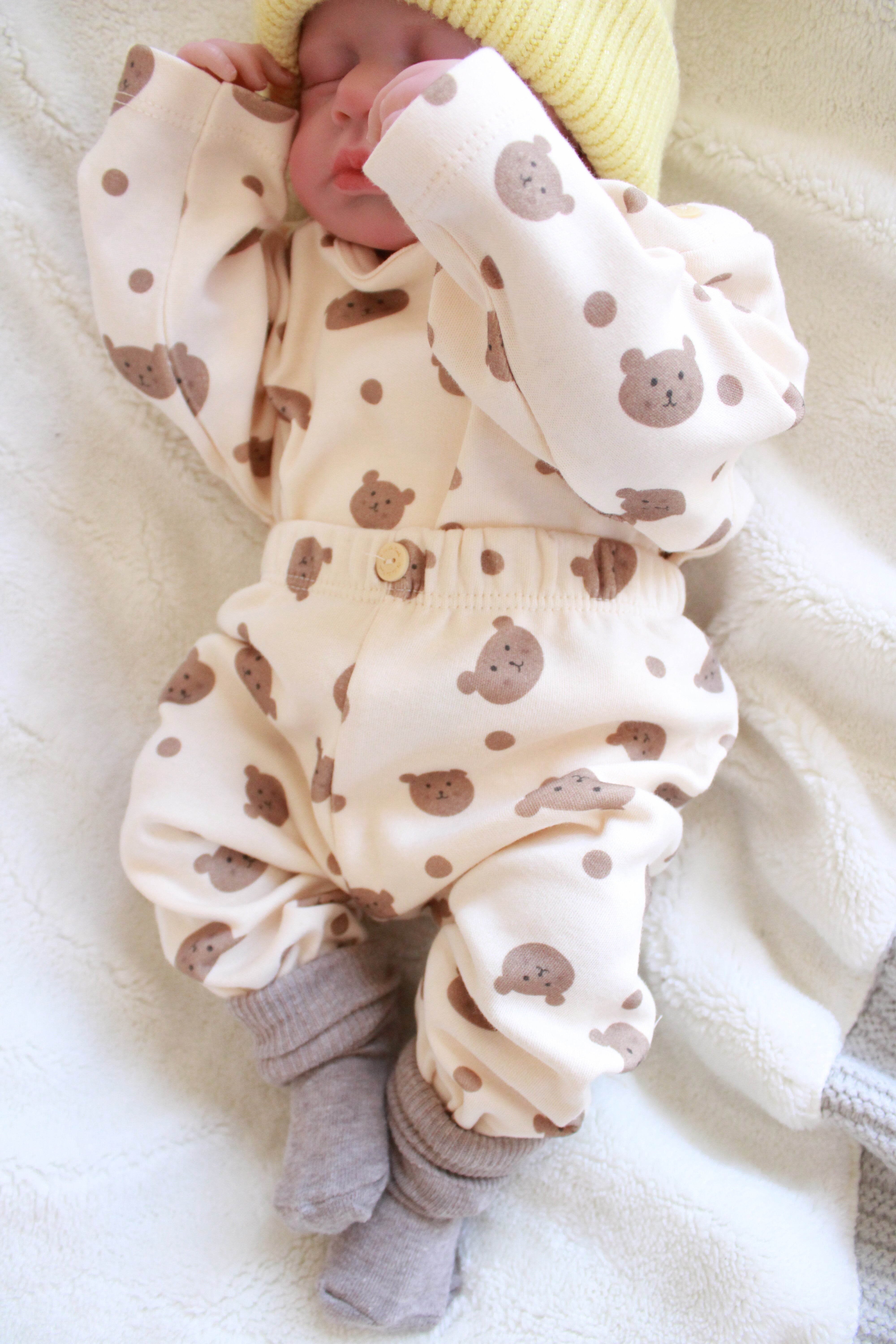 Minimalist beige baby set with brown teddy bear pattern and soft cotton fabric