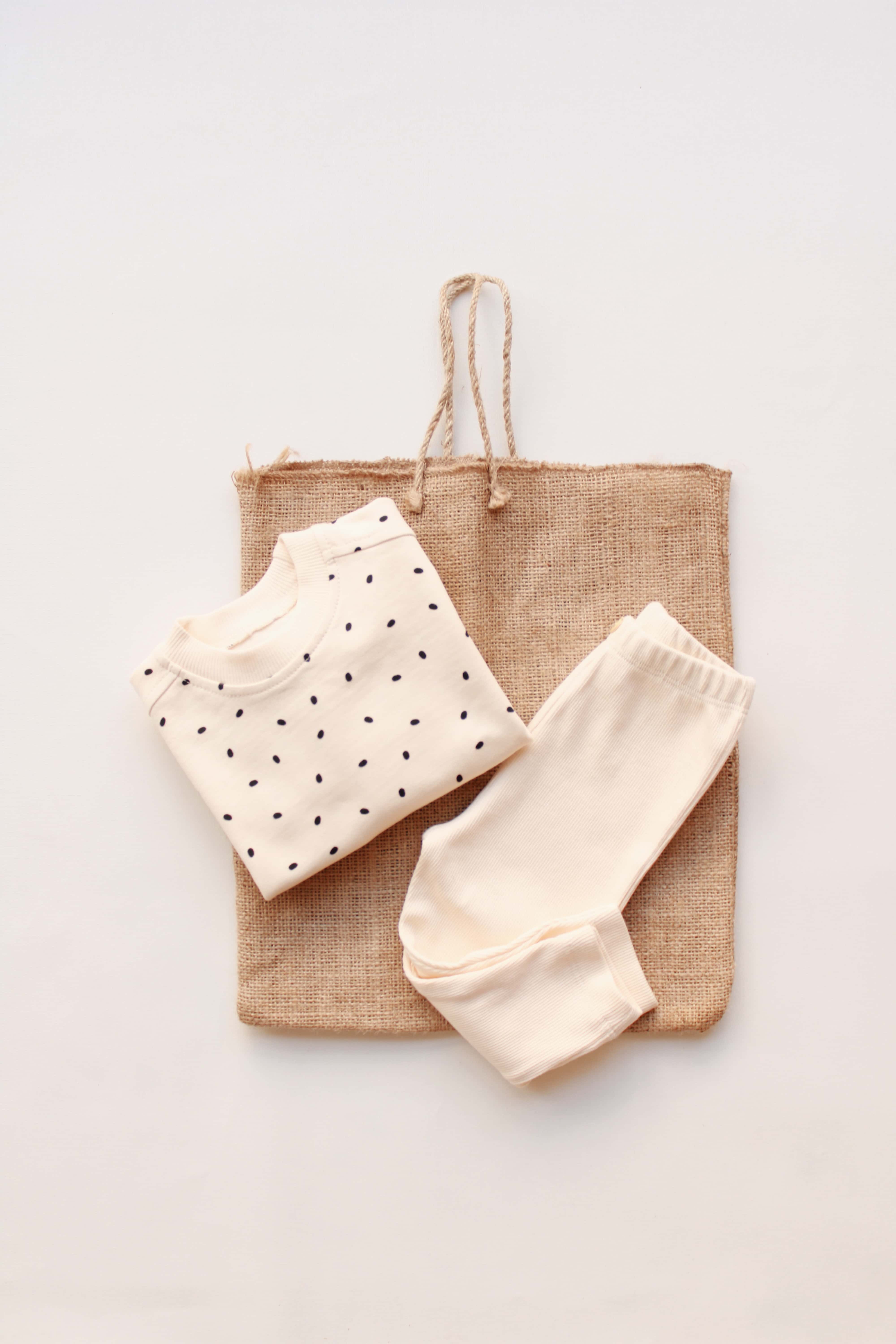 Neutral cotton baby outfit with dotted sweatshirt and cozy bottoms.