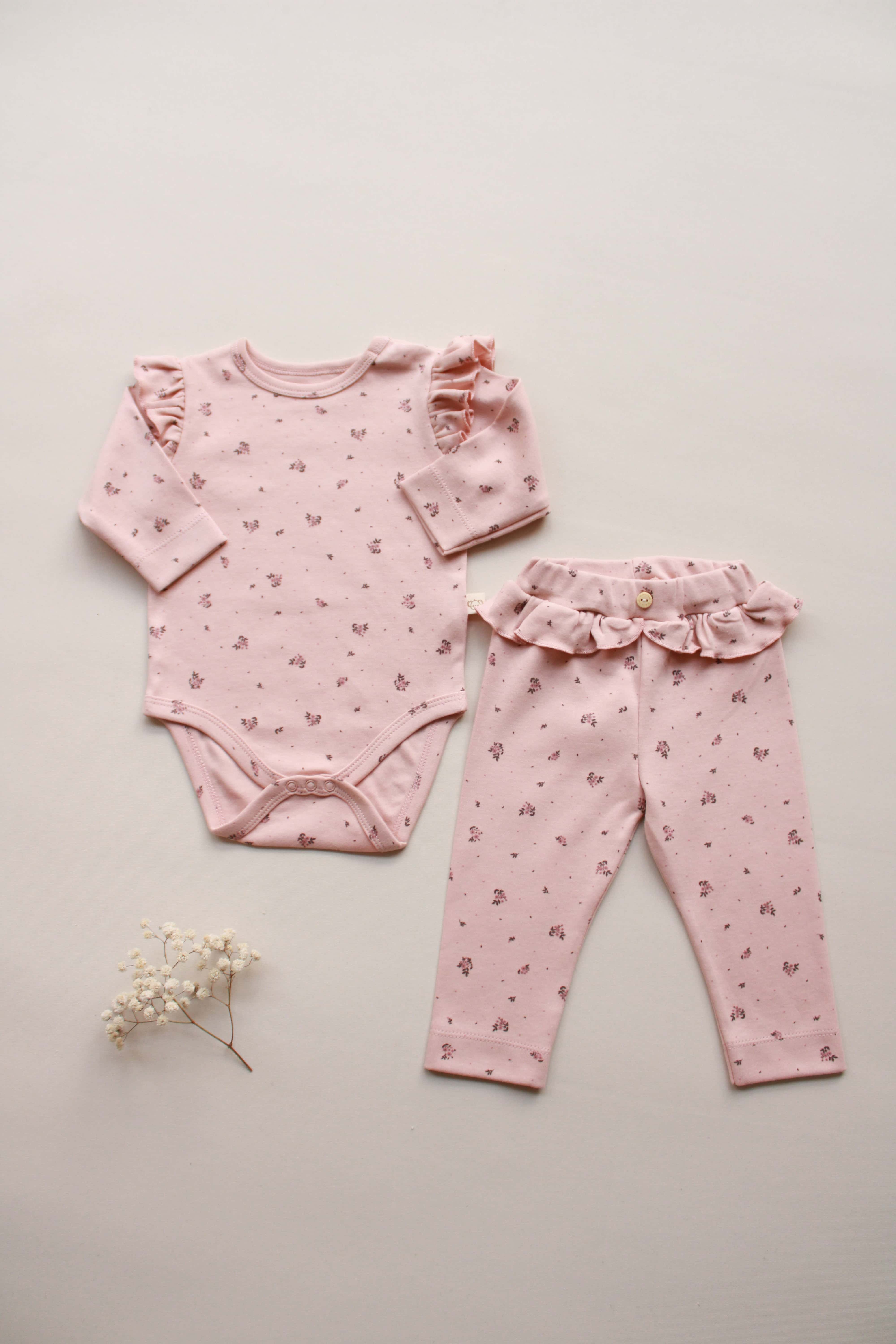 pink floral baby bodysuit and pants set with ruffle details
