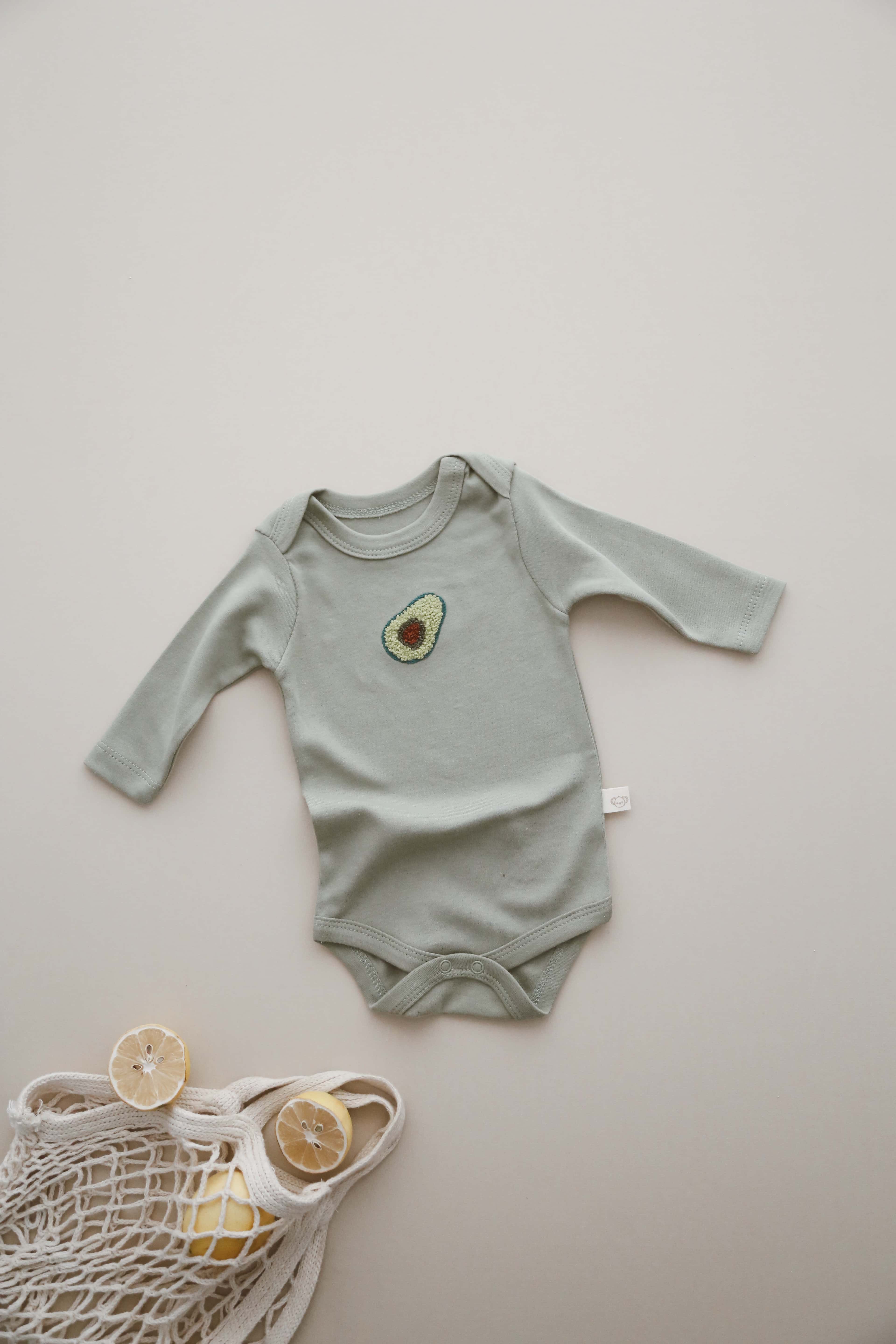 Cute avocado print long sleeve bodysuit, breathable organic cotton outfit for newborns.