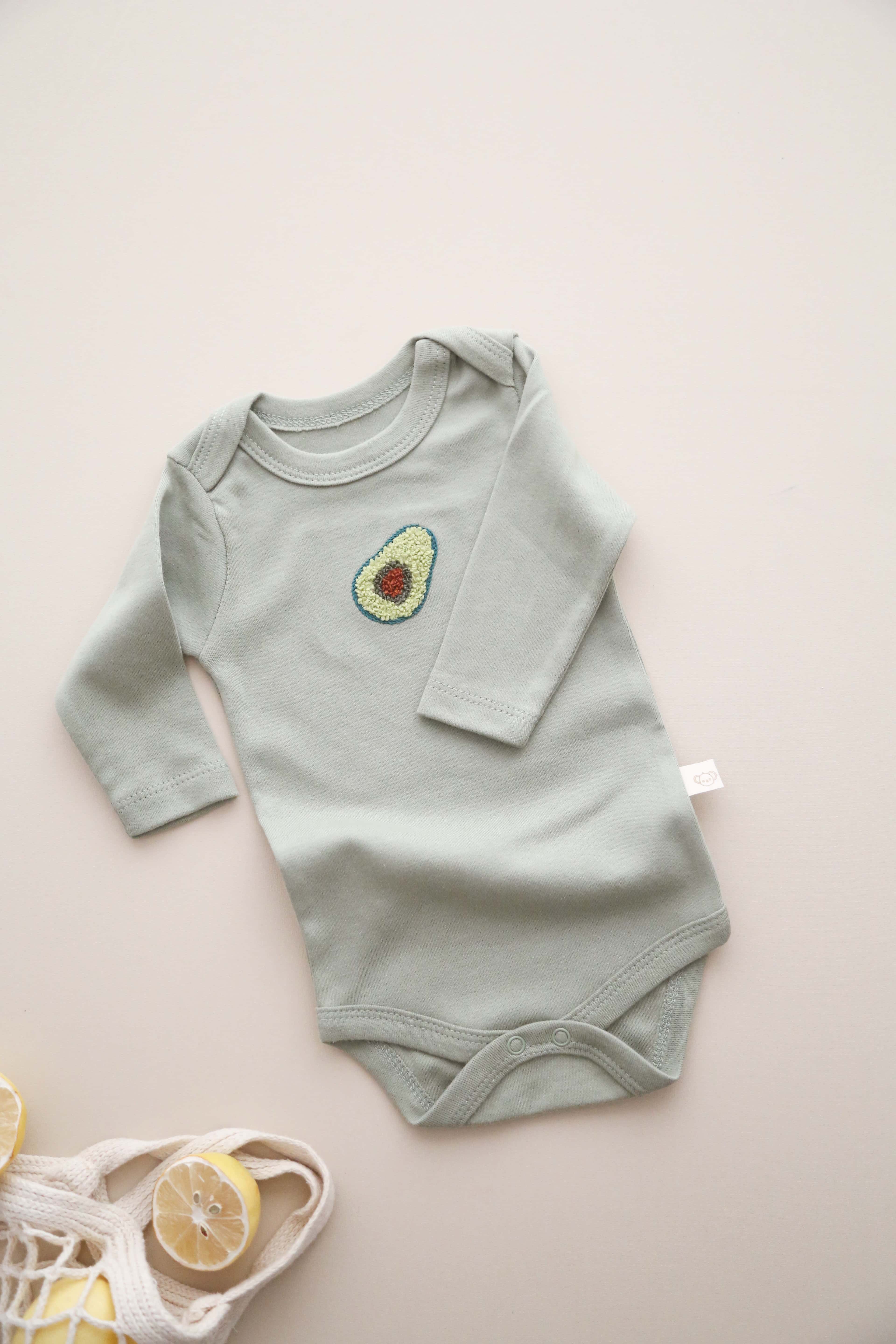 Unisex avocado design baby bodysuit with long sleeves, cozy organic cotton essential.
