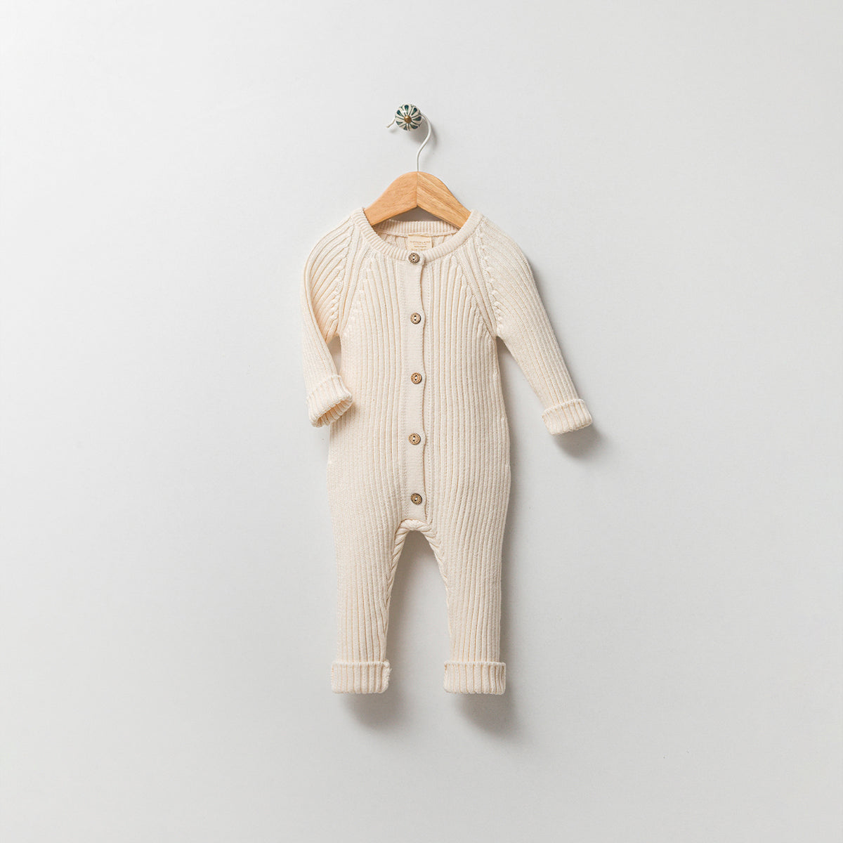 Knit cream baby onesie made from 100% organic cotton, soft unisex outfit for newborns.