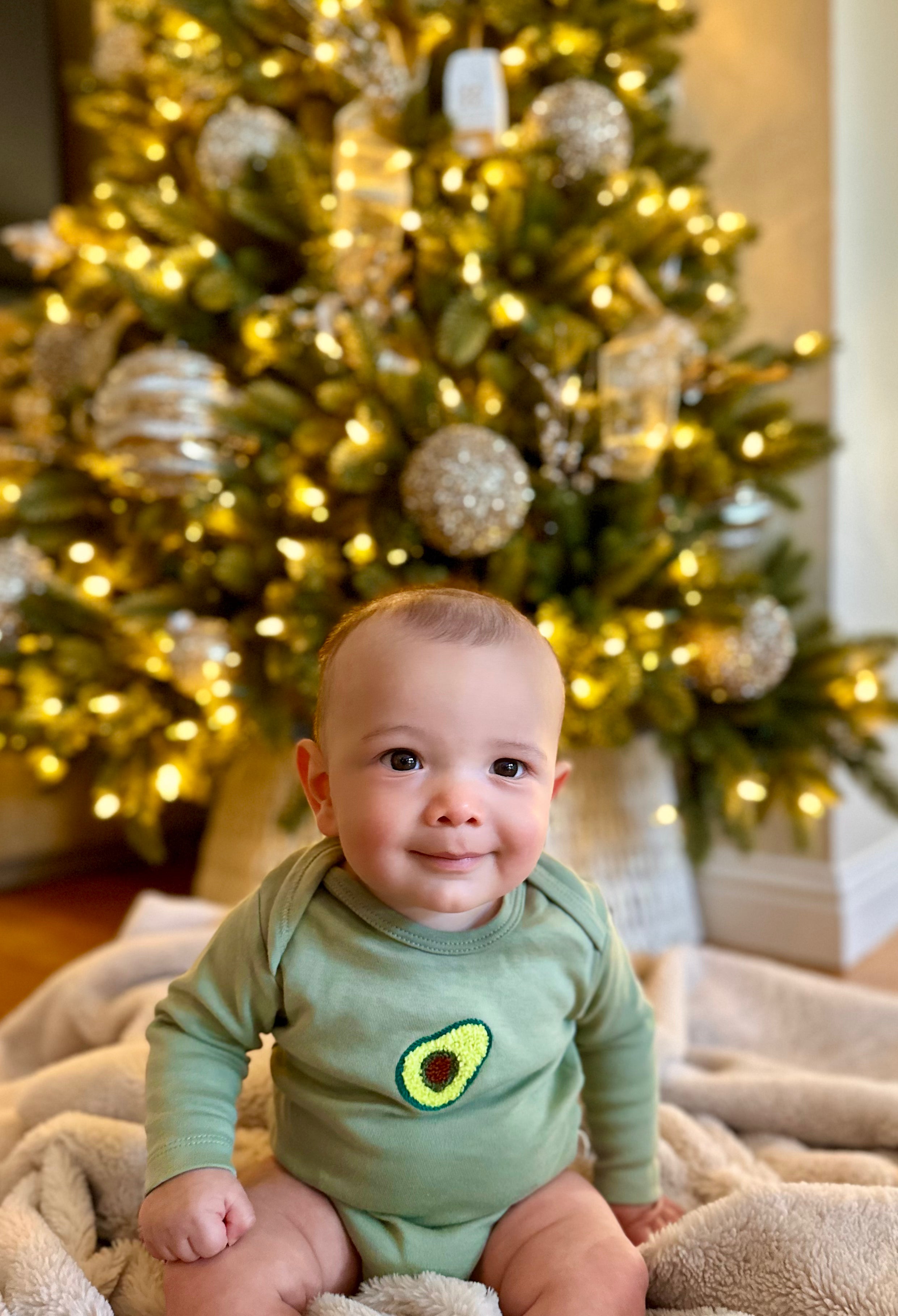 Avocado patterned long sleeve baby bodysuit made from soft organic cotton for infants.