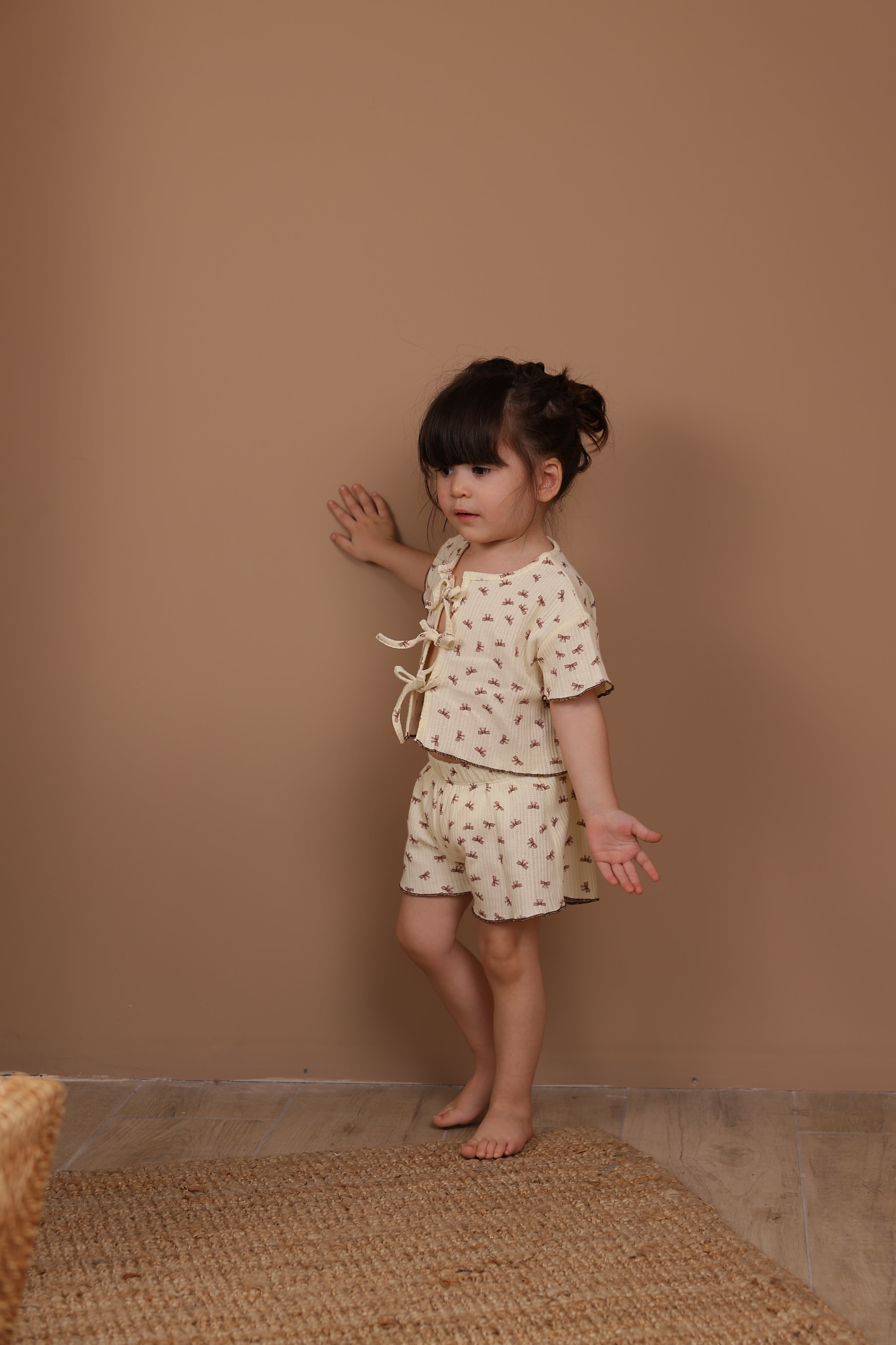 Petite bow tie-front baby clothing set, soft cotton outfit for infants and toddlers.