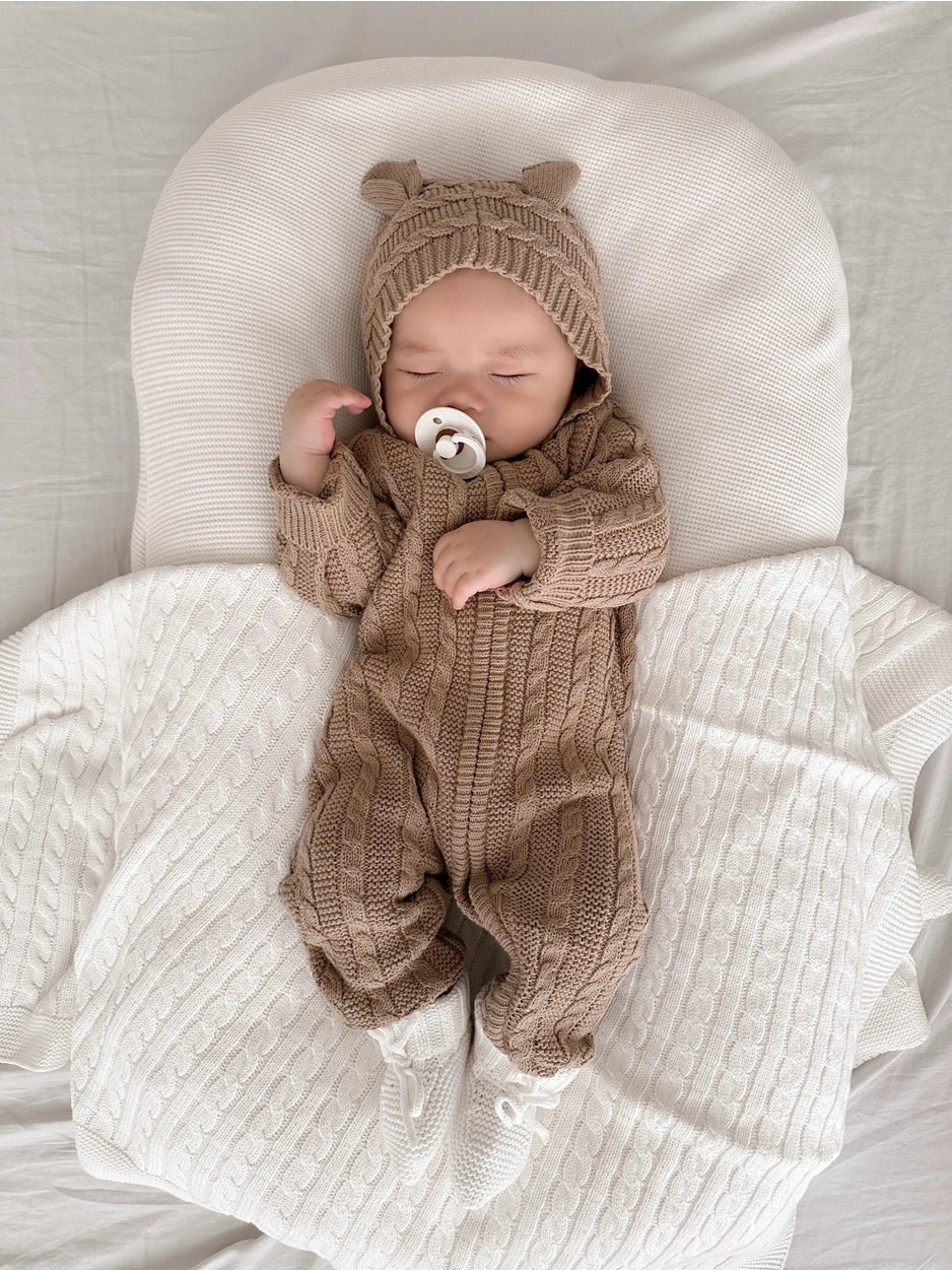 Cozy cable knit baby romper with bear ear hood.