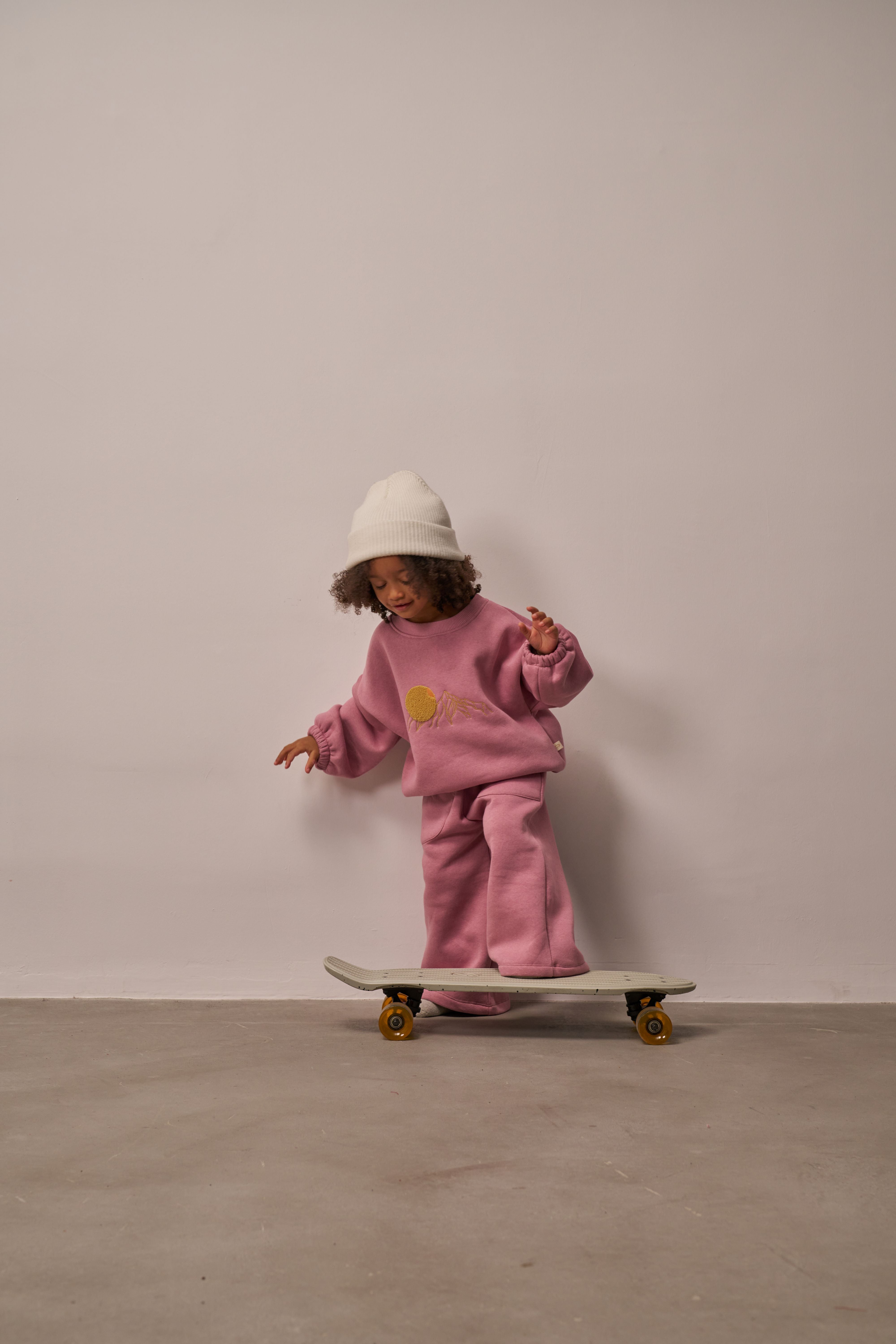 Cozy cotton fleece kids outfit in pink with sweatshirt and matching pants.