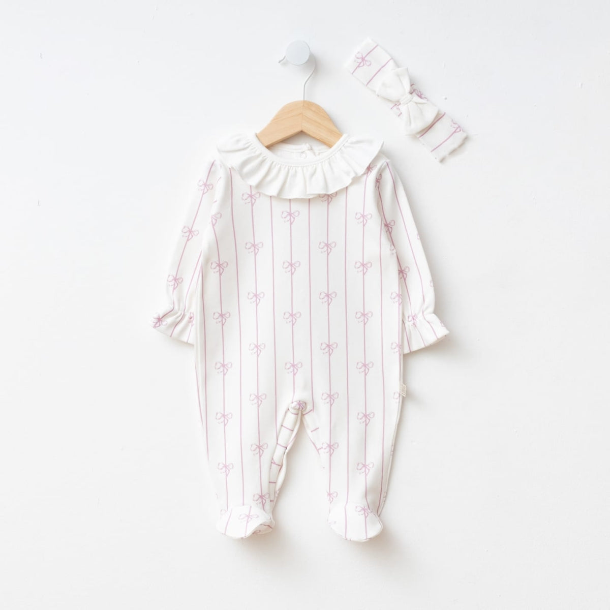 White baby romper with lilac bow pattern and ruffled collar