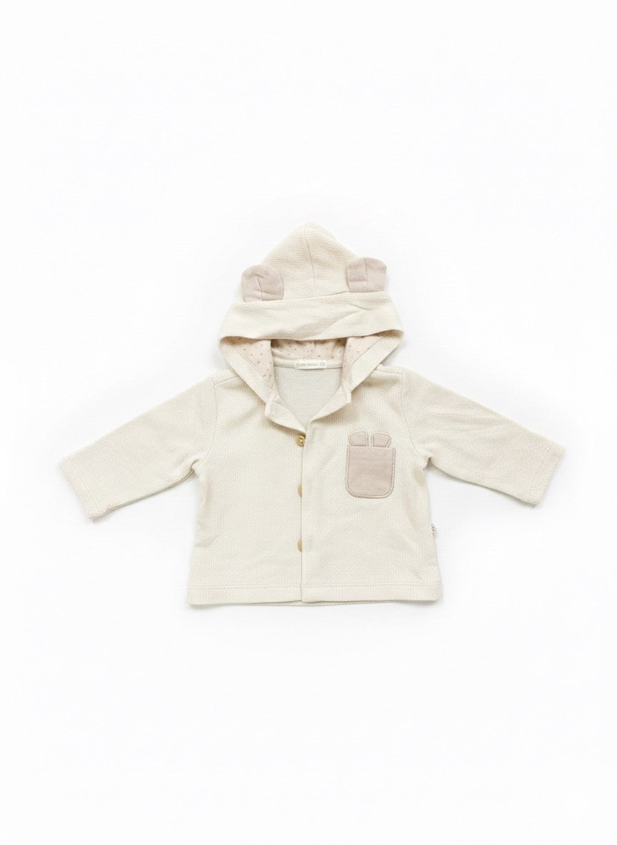 Three piece newborn clothing set in soft cream tones