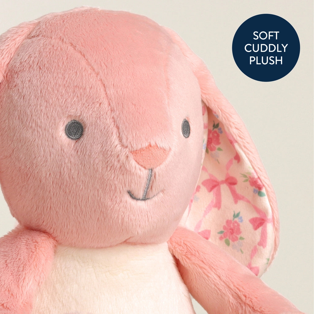 Child cuddling soft pink floral bunny plush