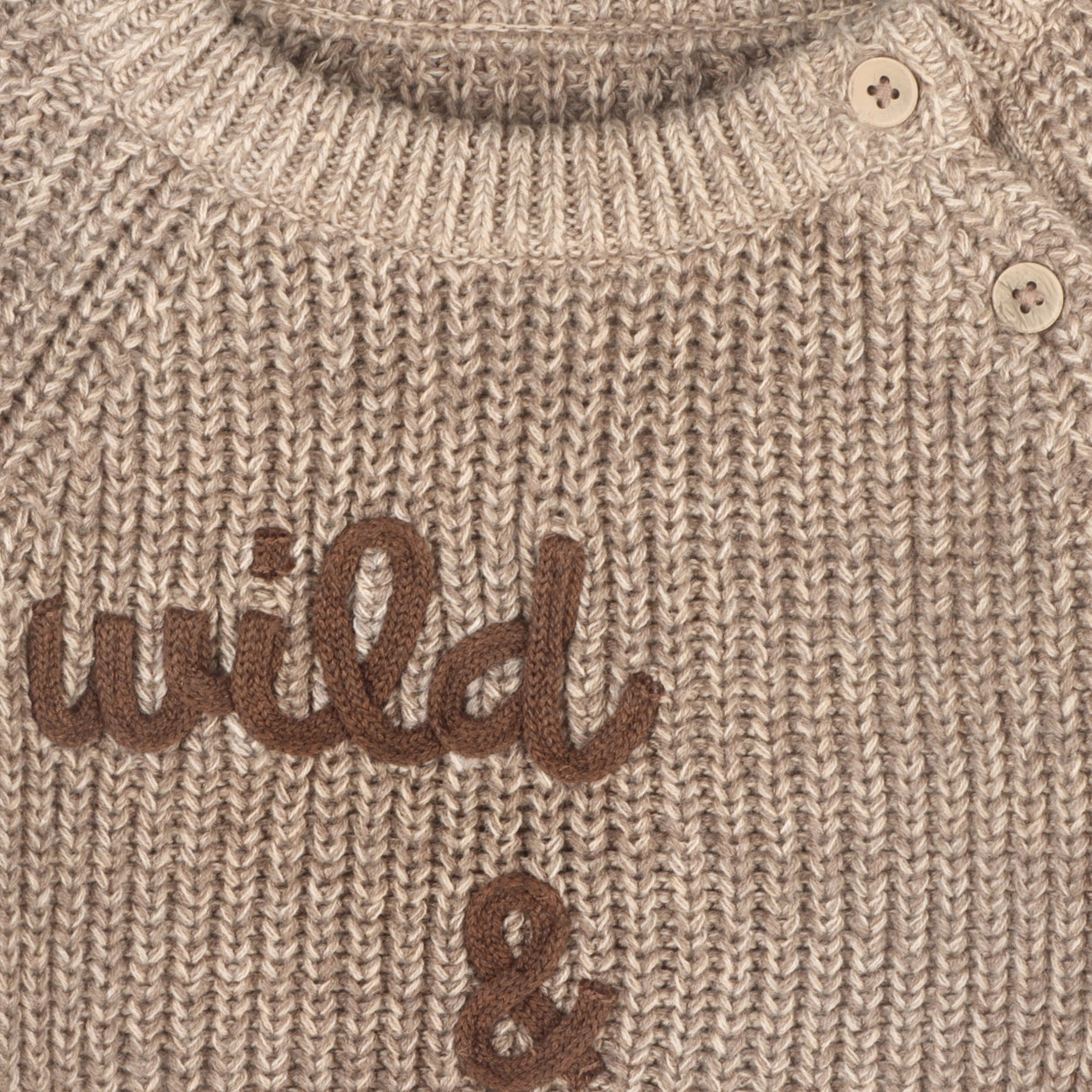 Soft knit baby sweater with embroidered Wild & Free lettering.