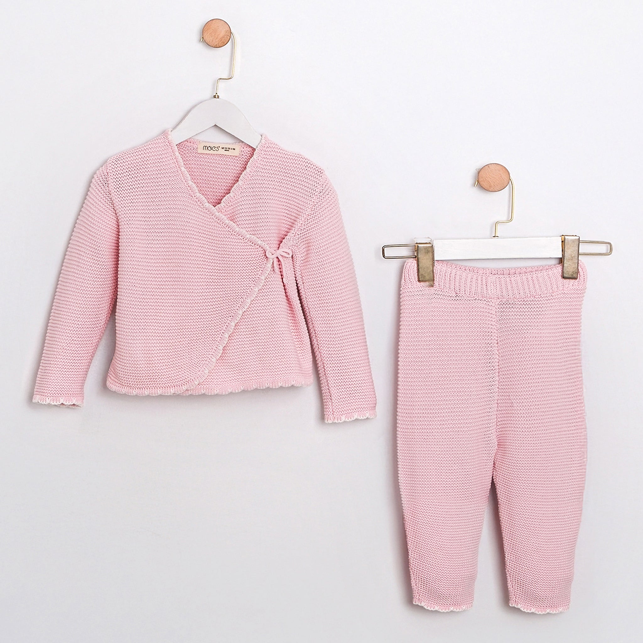 Pink knit baby set with wrap cardigan and matching pants, soft cotton texture.