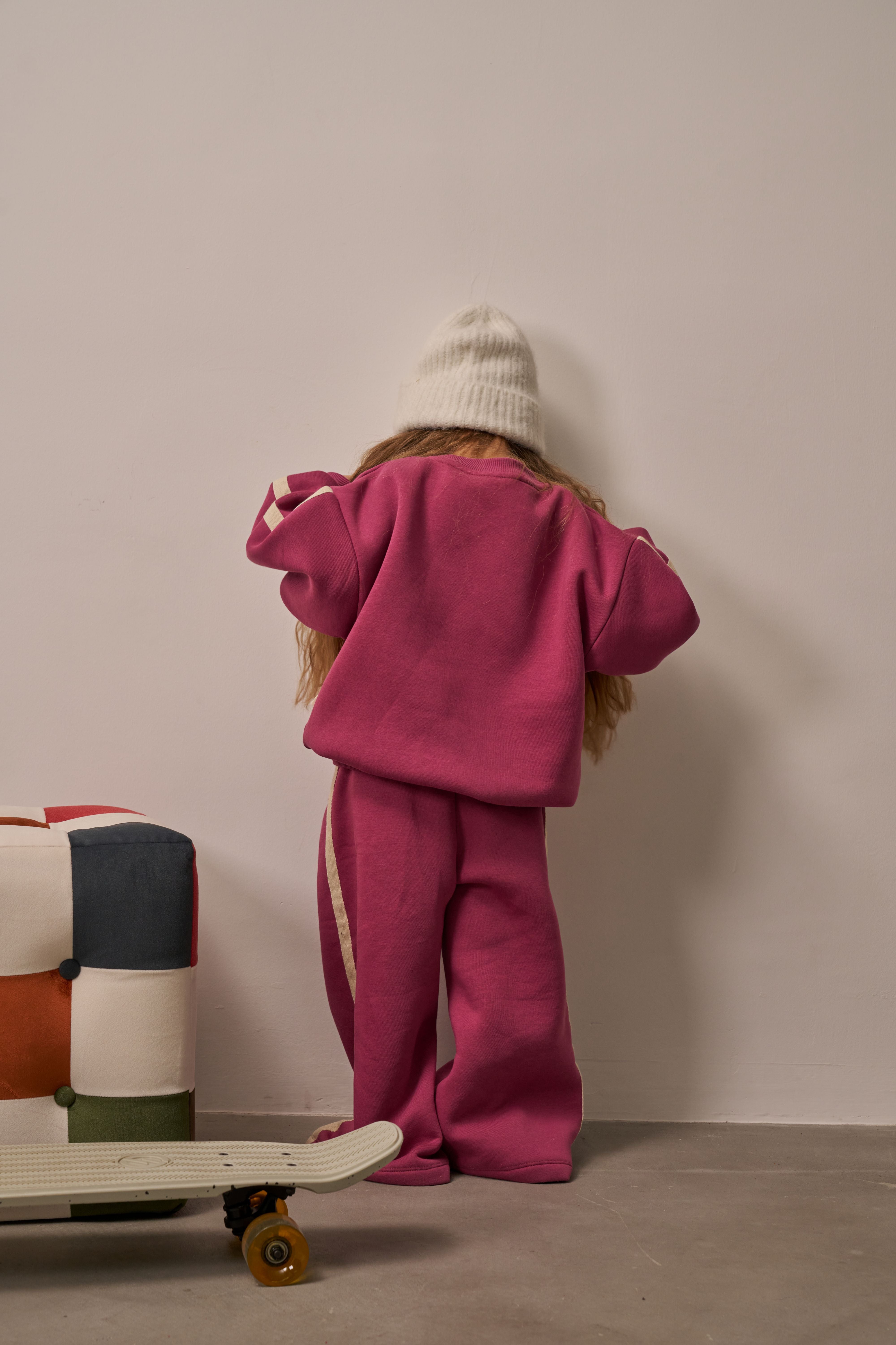 Trendy girl outfit with magenta sweatshirt and striped joggers