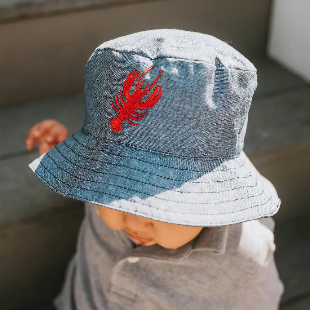Chambray blue infant sun hat featuring a red lobster design and stitched brim.