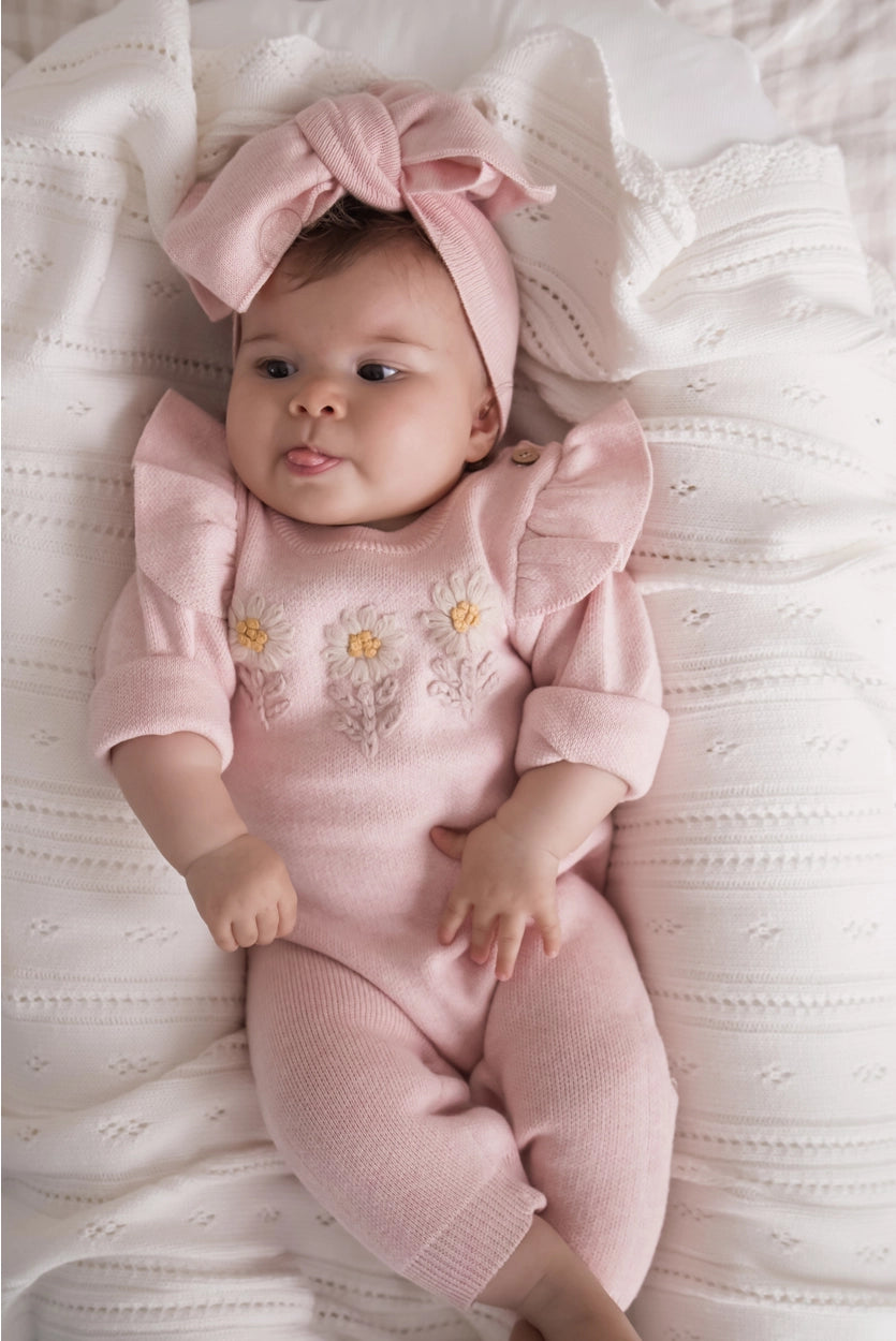 Organic cotton floral knit baby jumpsuit with matching bow headband.