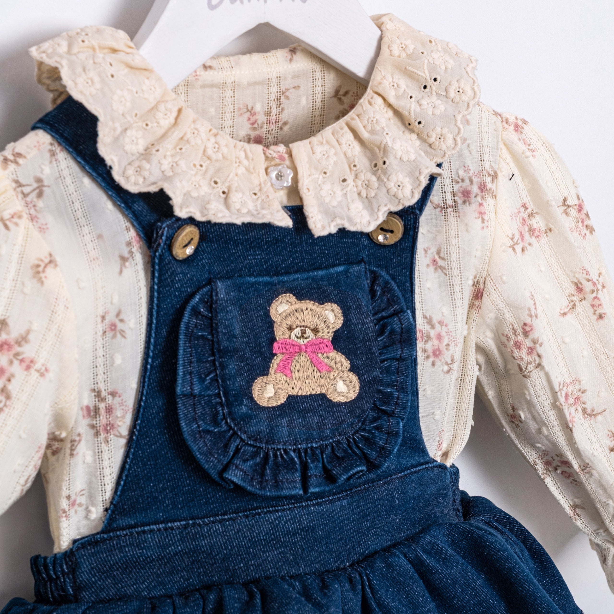 Vintage style baby girl outfit with floral top and denim pinafore