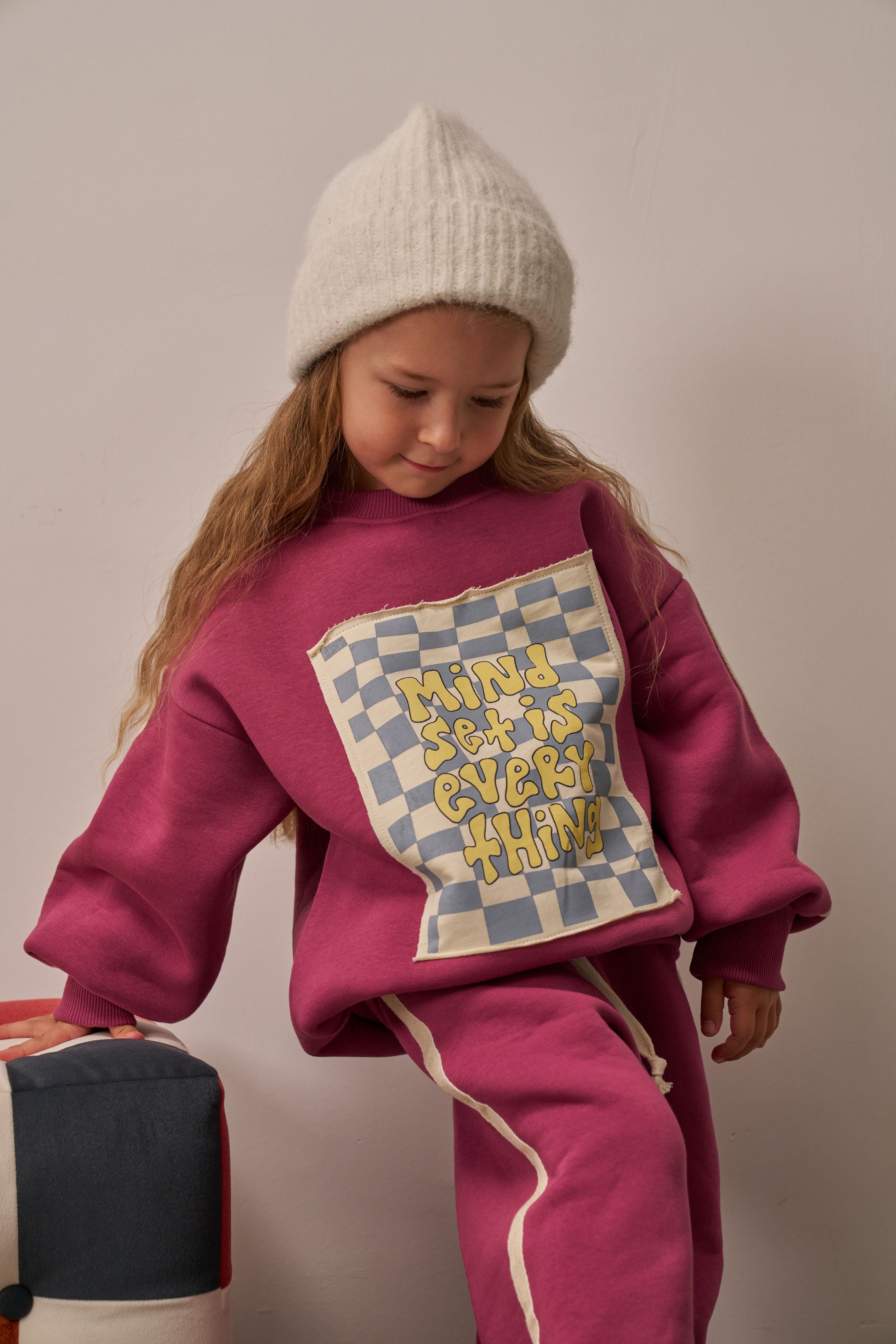 Comfortable children’s tracksuit in pink with white side stripes.