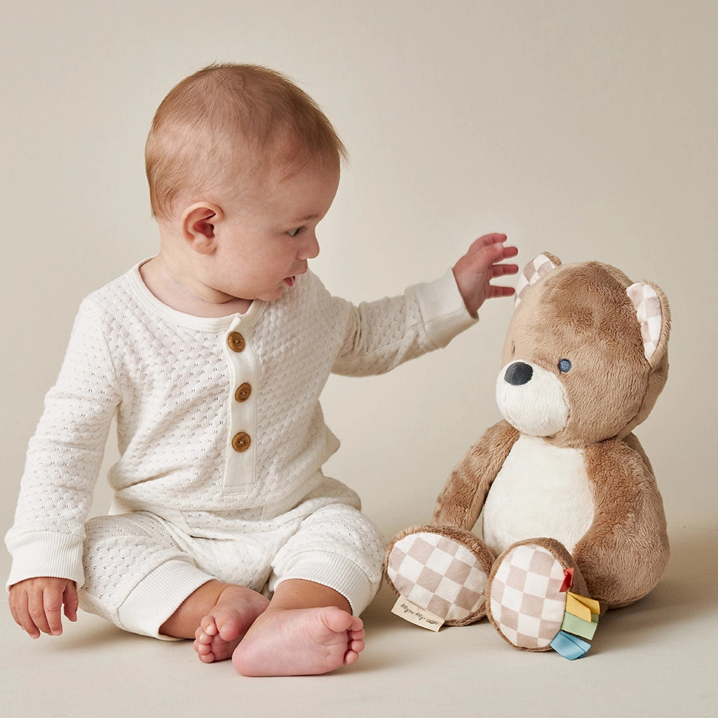 Soft teddy bear baby toy with colorful sensory ribbons