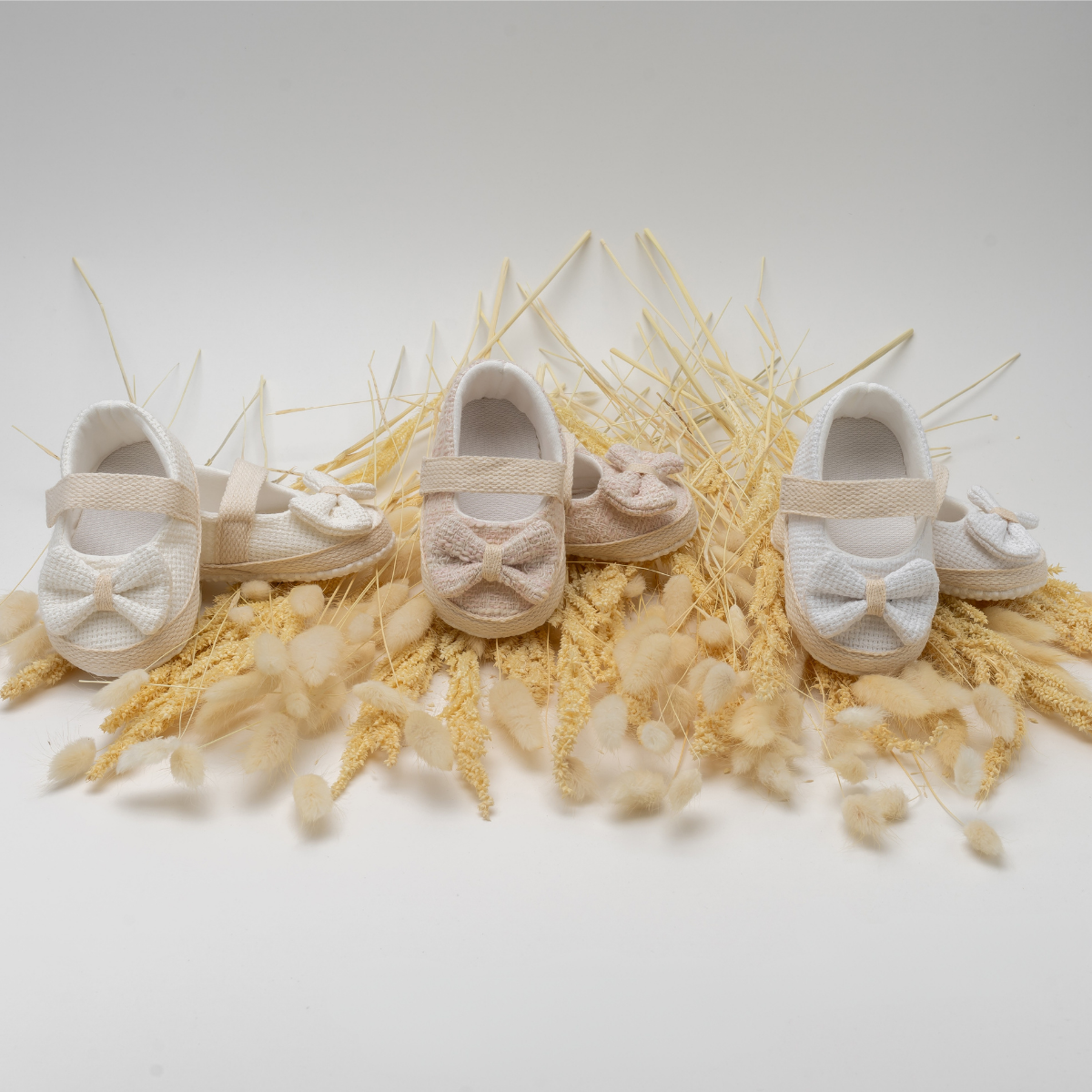 Baby soft-sole shoes with bow detail displayed on neutral background