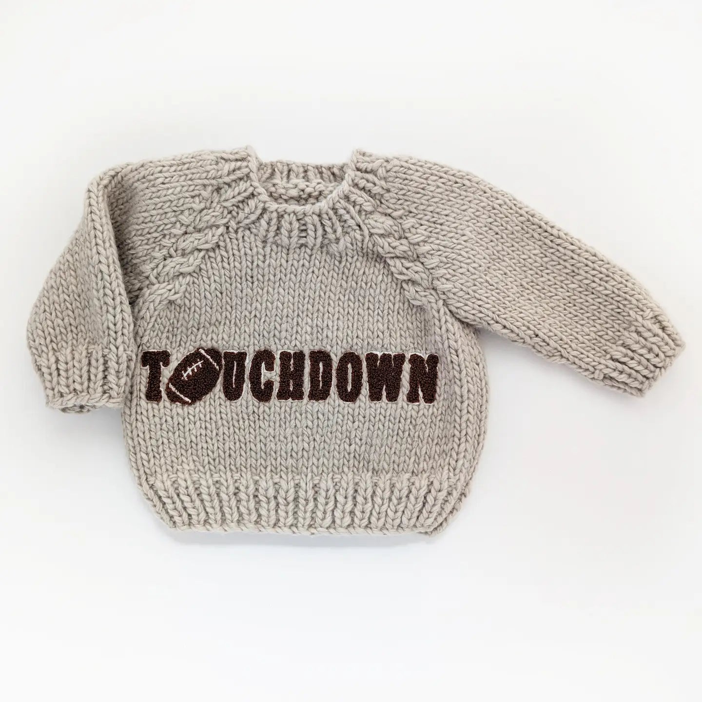 Knitted sweater with 'Touchdown' text on a white background