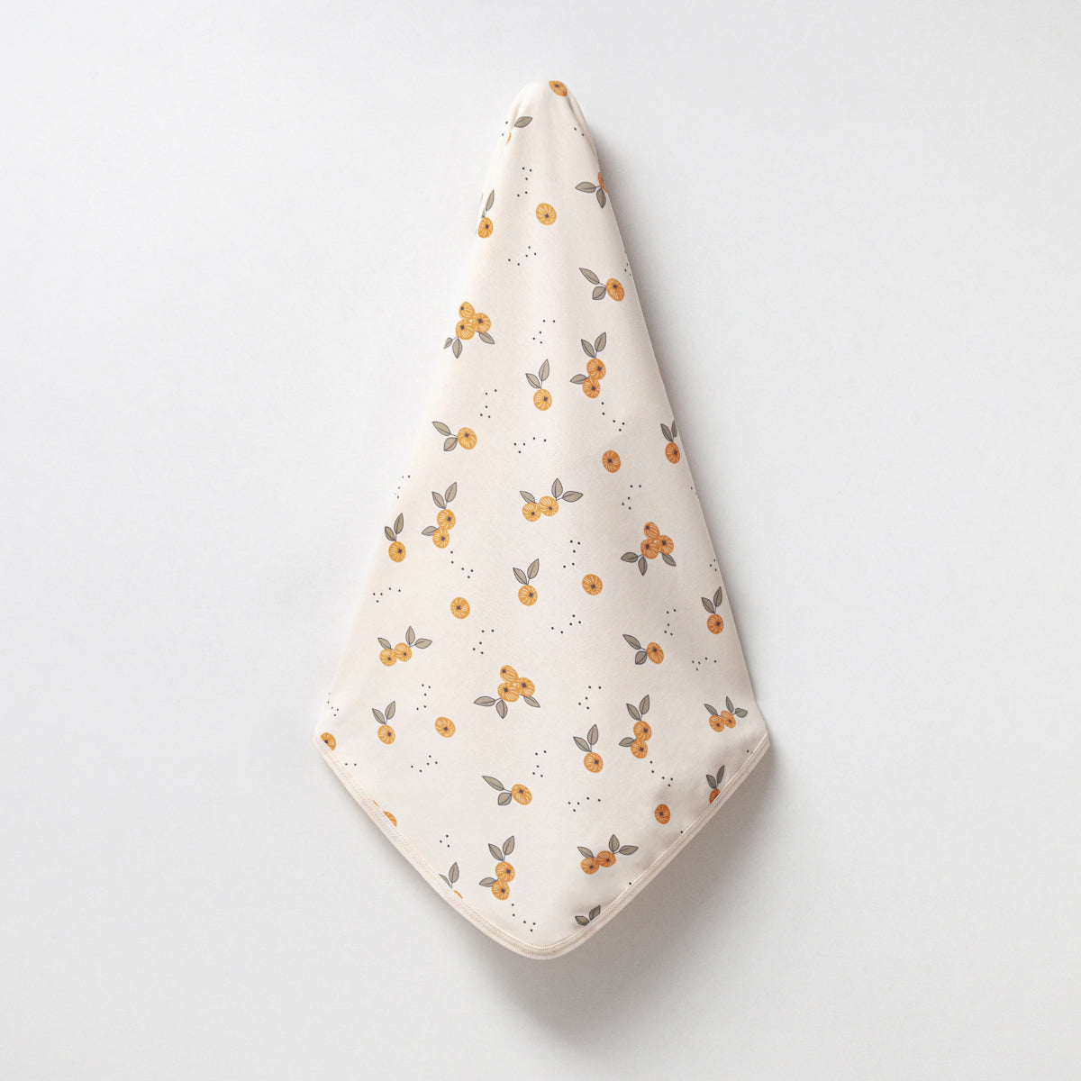 Cream baby blanket with orange blossom print and organic cotton fabric.