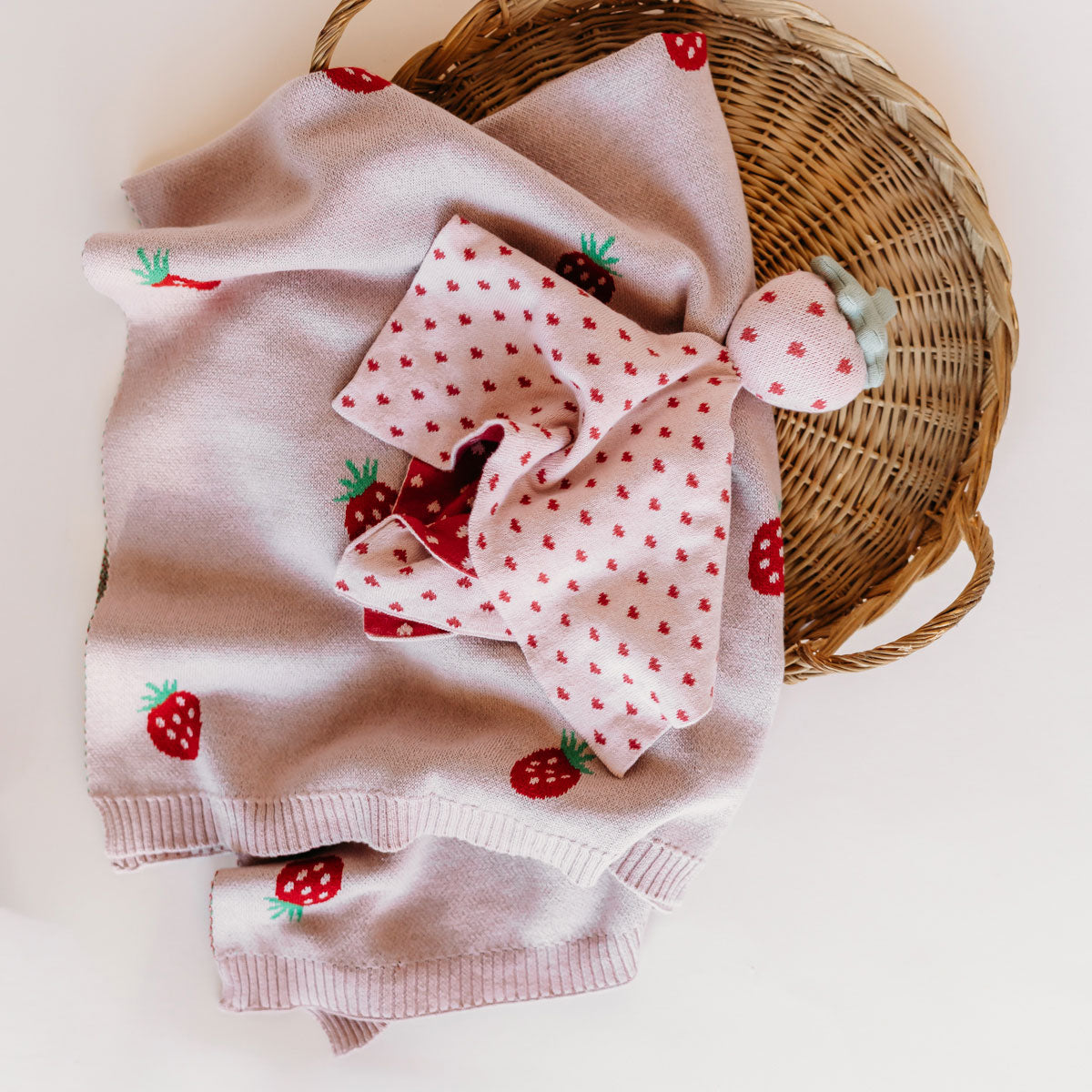Cozy strawberry knit baby blanket for newborns and infants.