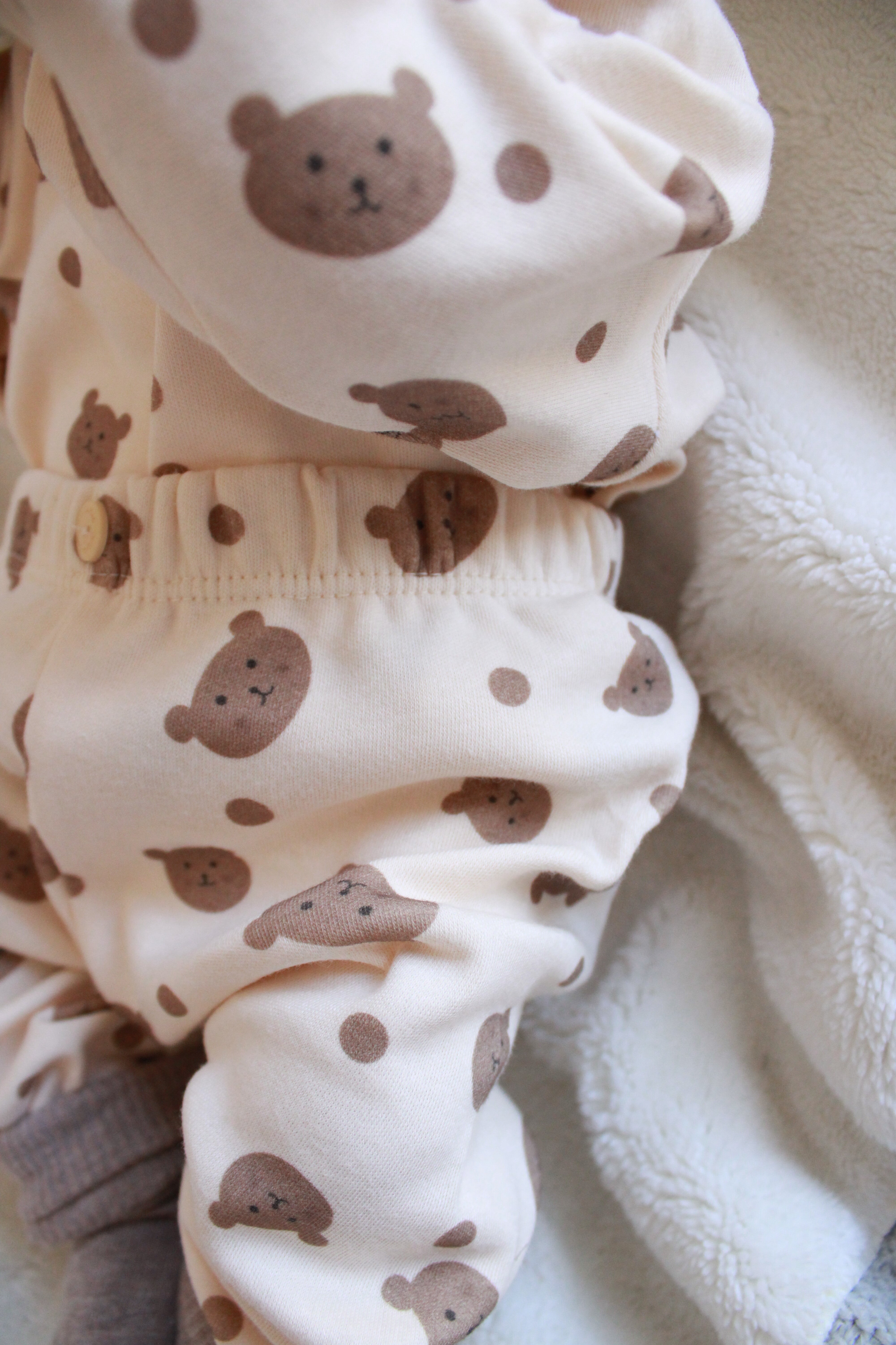 Adorable beige baby clothes set with teddy bear pattern and soft fabric