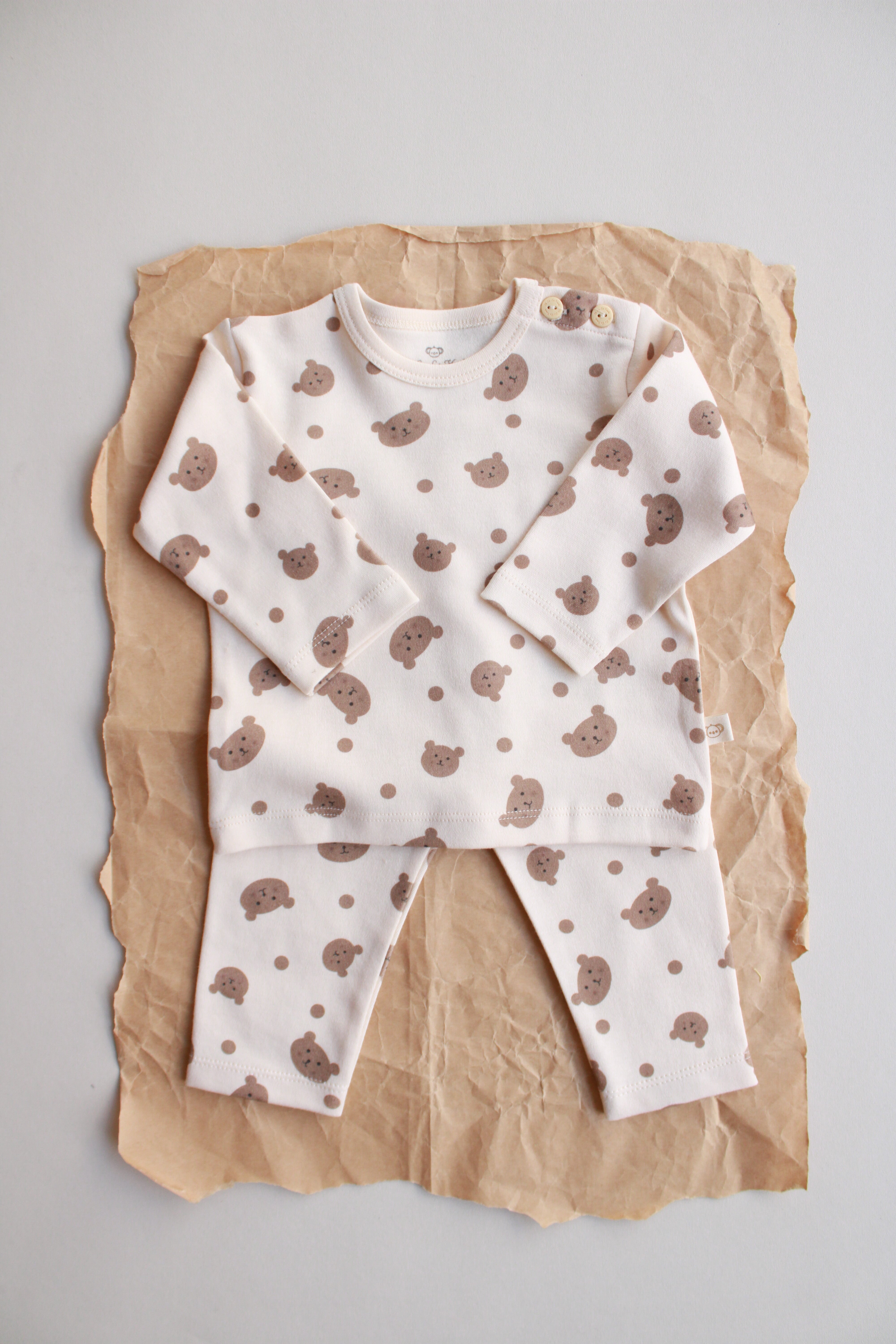 Beige baby outfit with all-over teddy bear print and matching pants