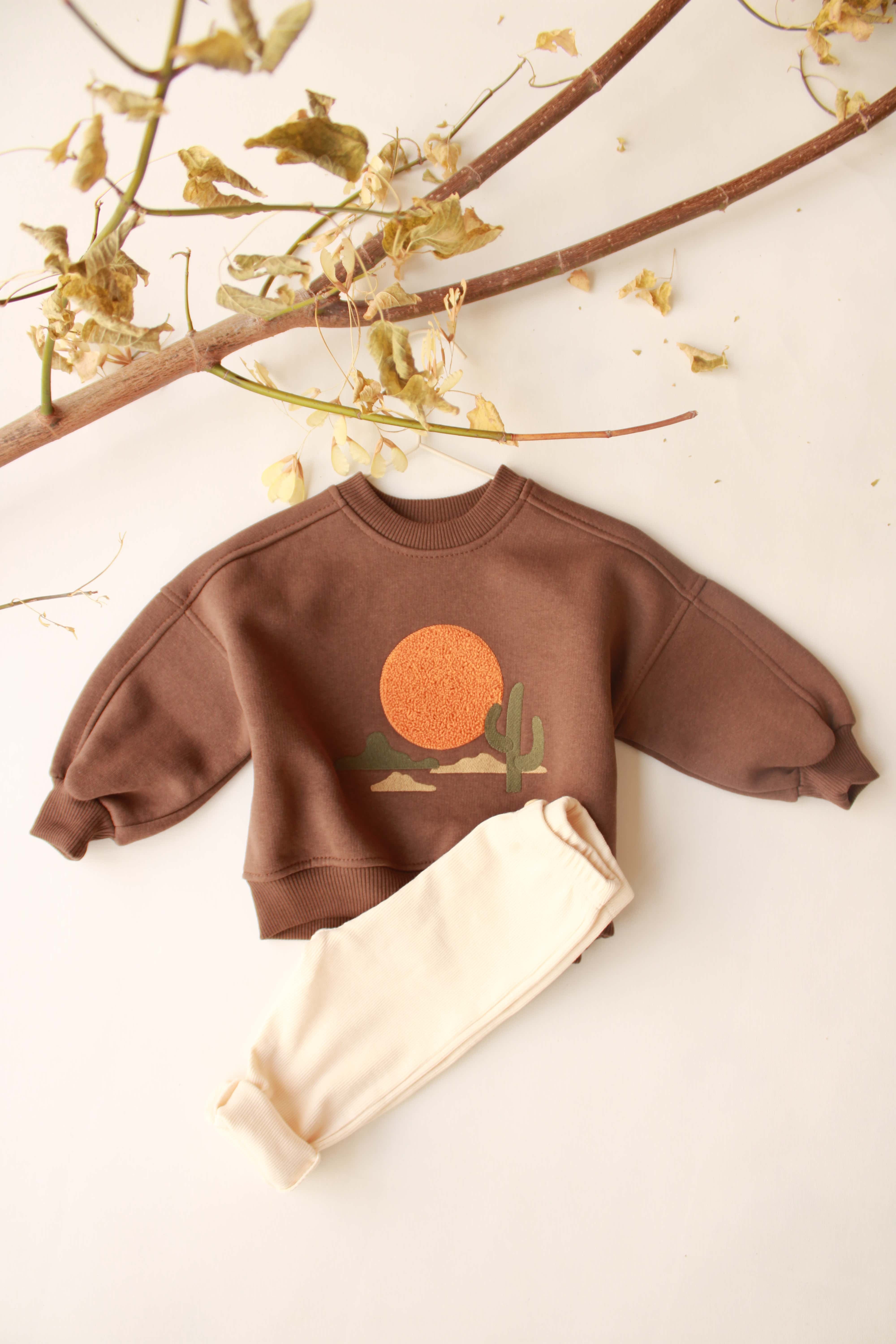 Two-piece baby outfit with mountain print sweatshirt and matching pants.