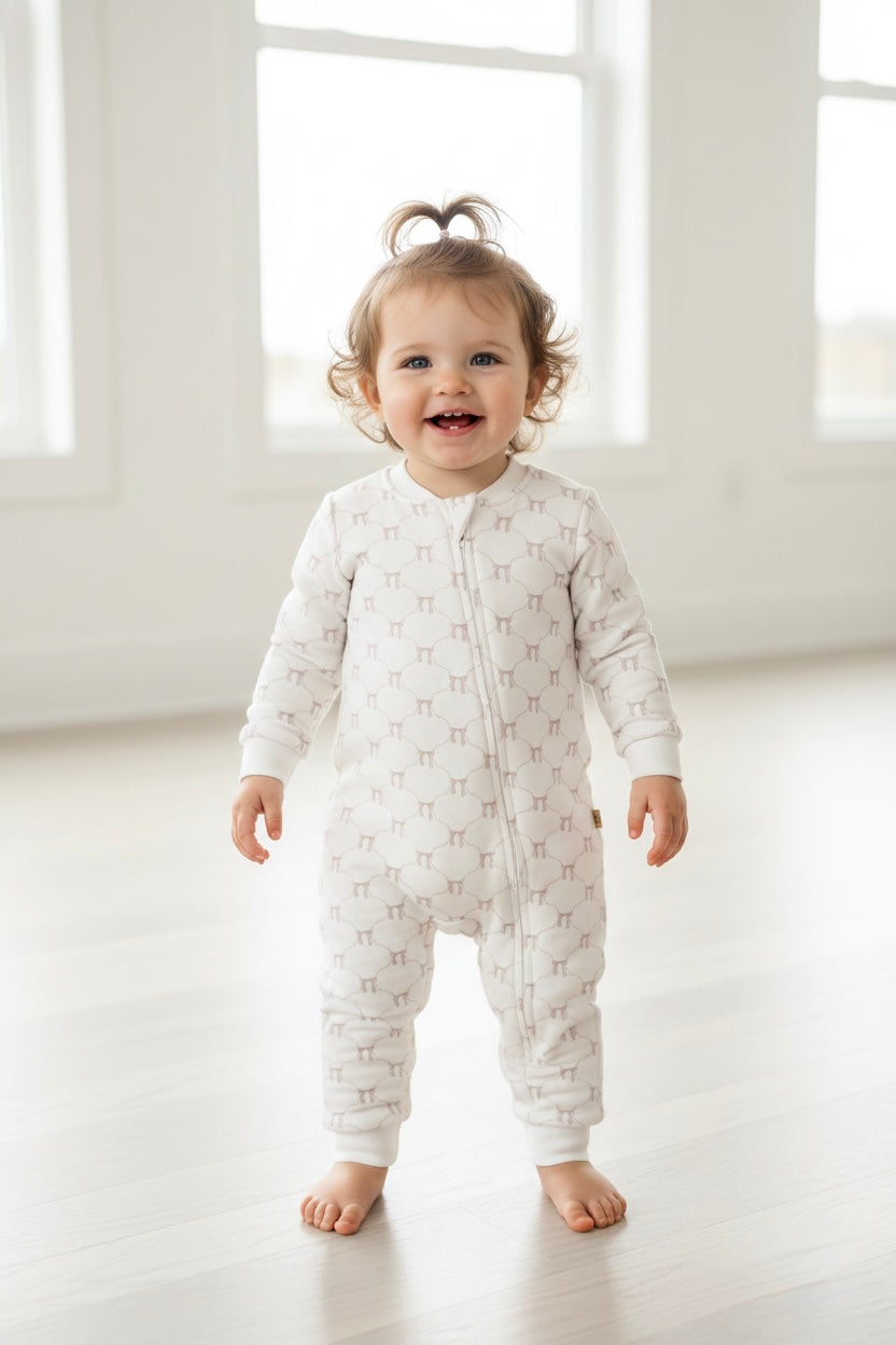 Cream baby romper with allover blush bow pattern