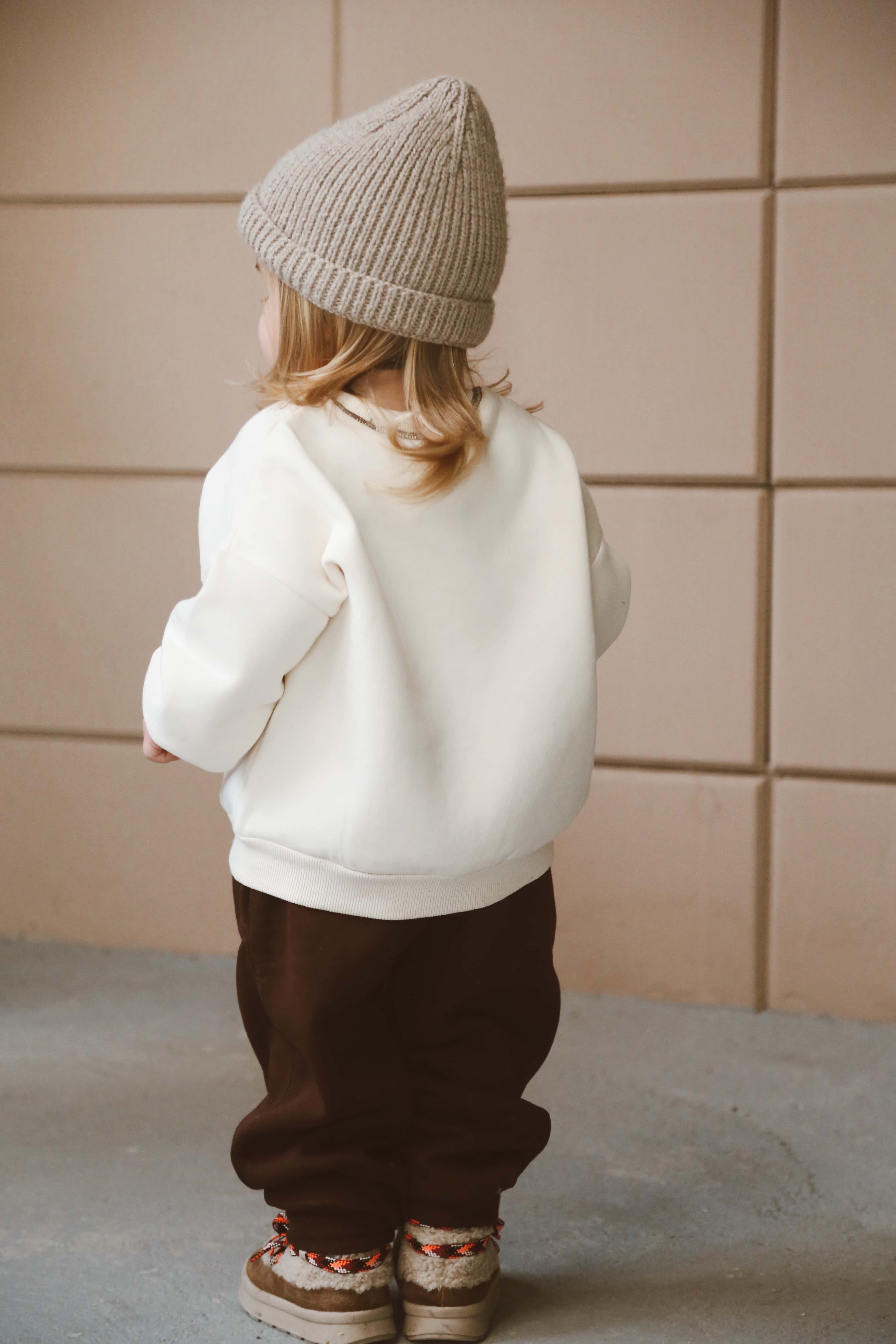 Unisex baby outfit with cream sweatshirt and brown joggers made from soft cotton.