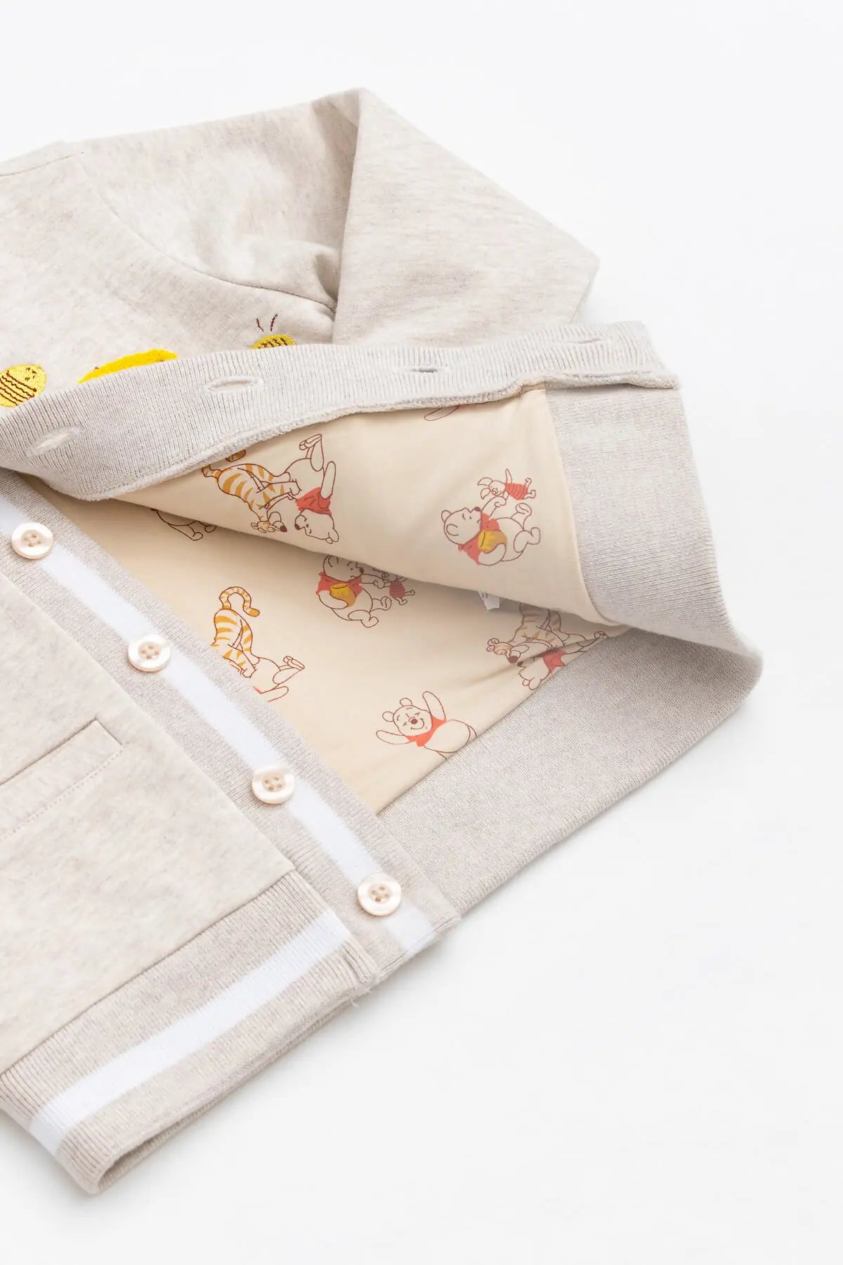 Neutral organic cotton children's jacket with embroidered Pooh bear perfect for everyday wear.