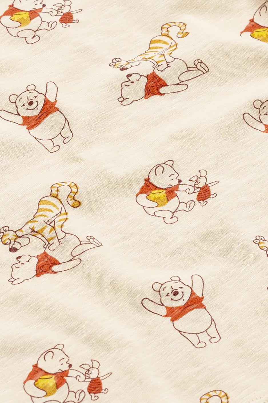Toddler wearing Disney Winnie the Pooh cotton pajamas with playful Pooh, Piglet, and Tigger print.
