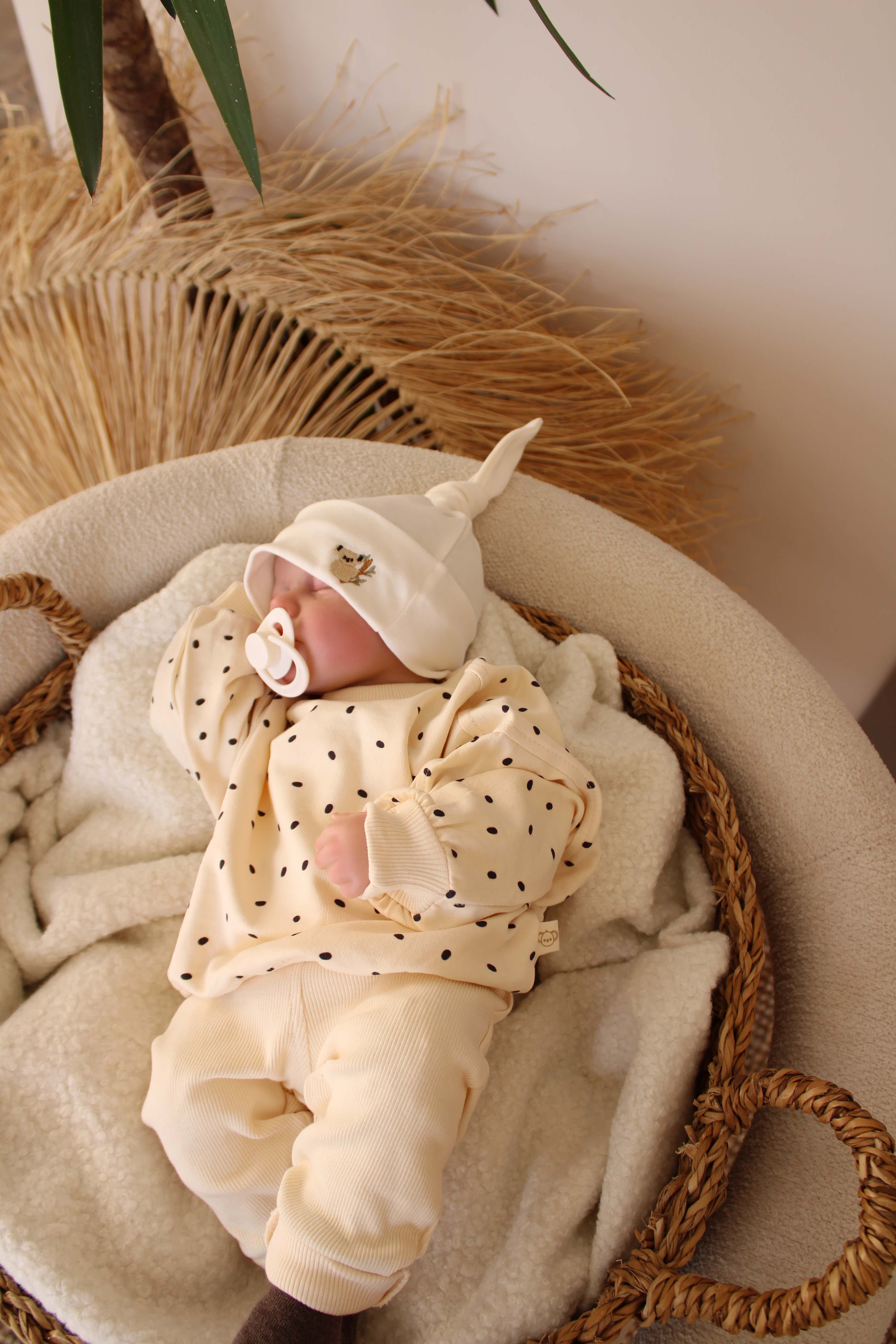 Neutral beige baby set with soft cotton sweatshirt and dotted pattern.