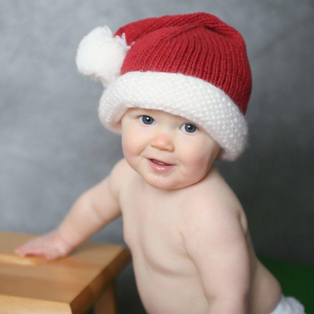 baby wearing red and white knit santa hat with pom pom
