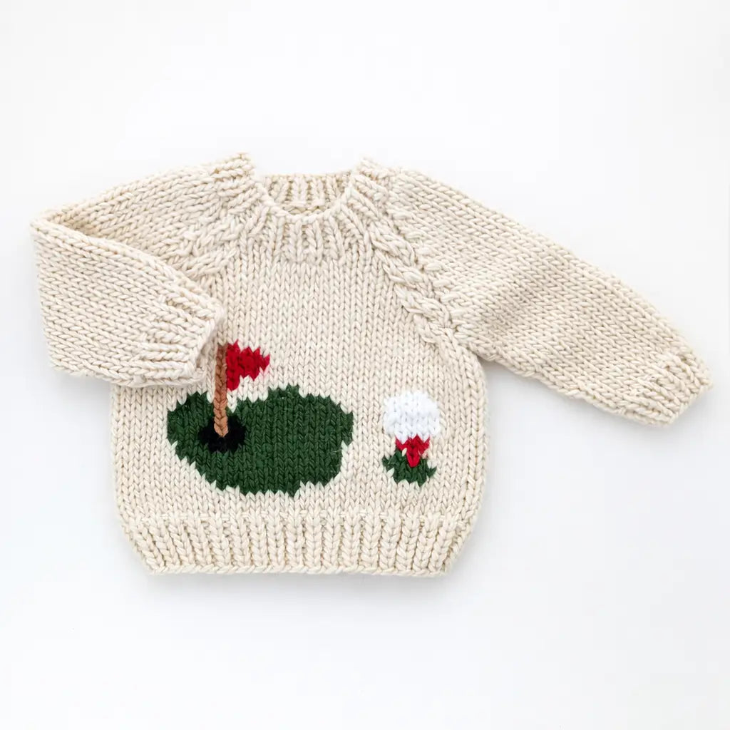 Hand knit cream baby sweater featuring a golf green and golf ball design.