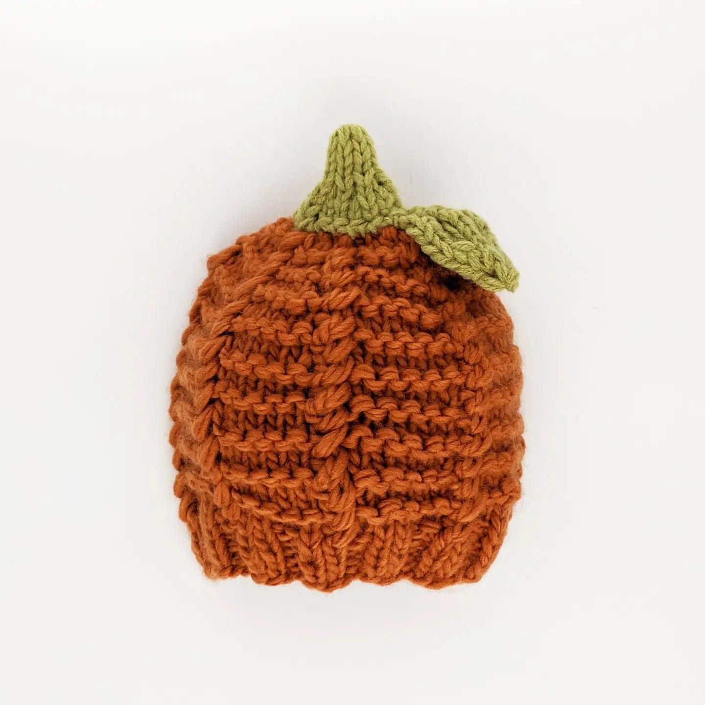 Knitted pumpkin-shaped item with a green stem on a white background
