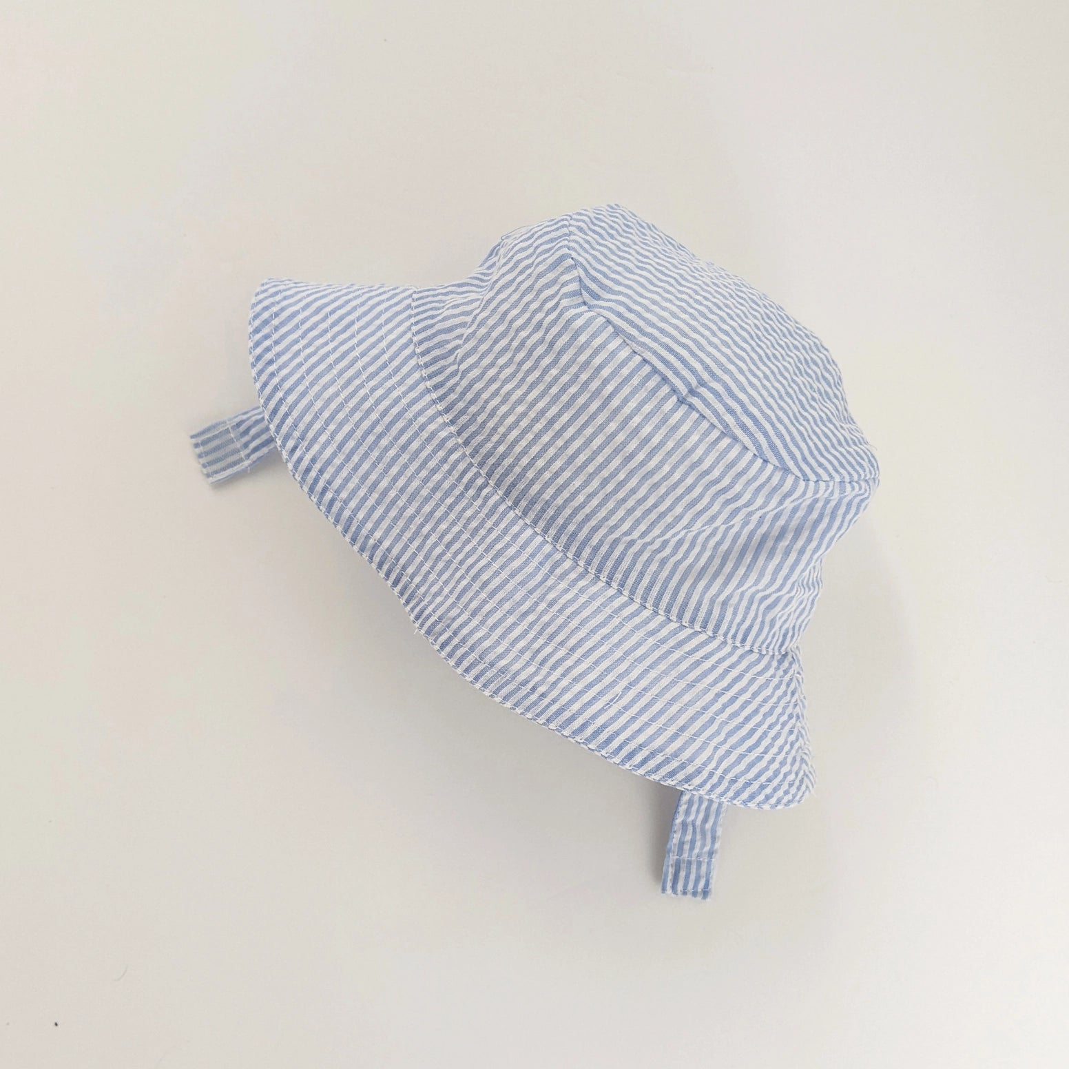 Baby wearing blue seersucker sun hat