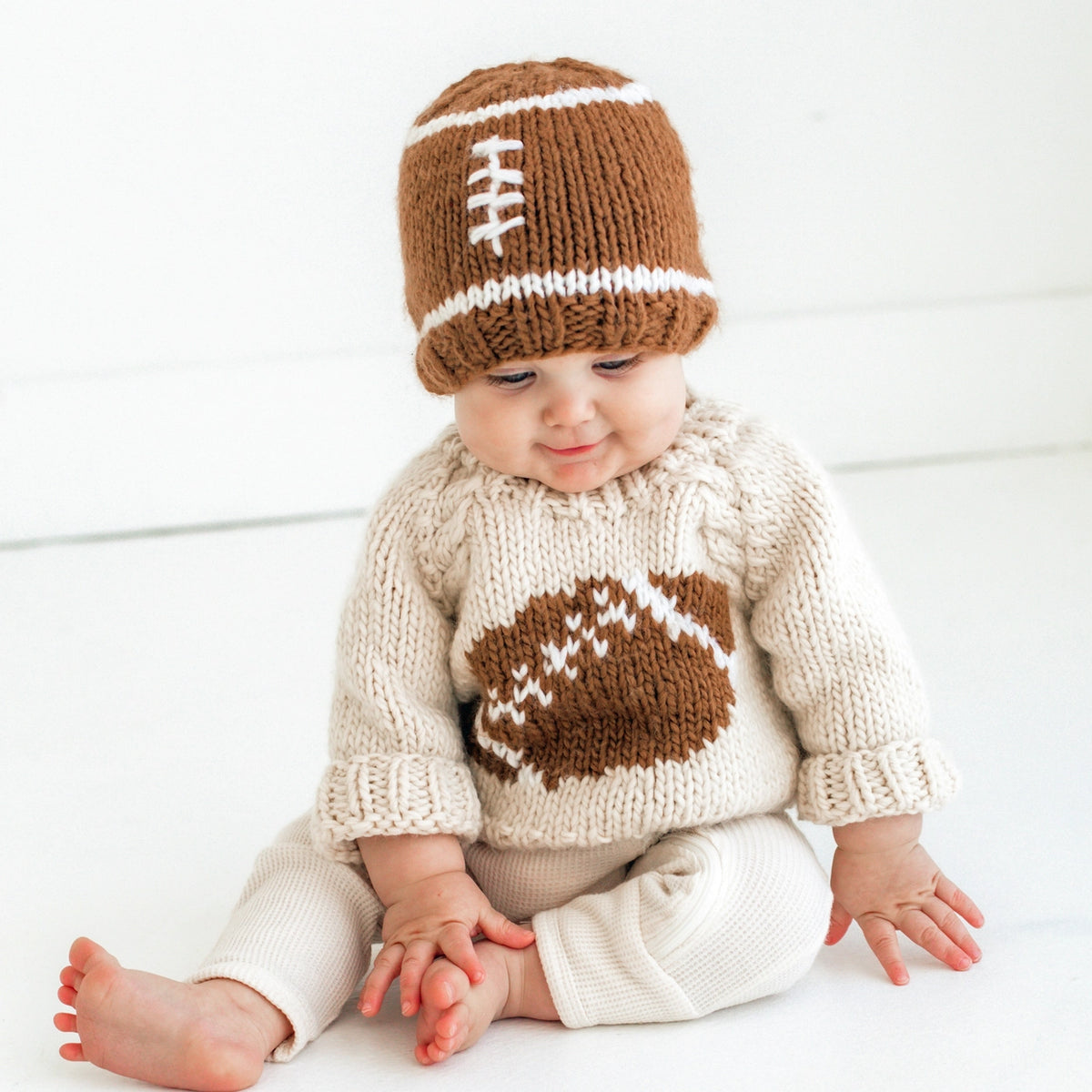 Baby wearing a cozy cream football sweater